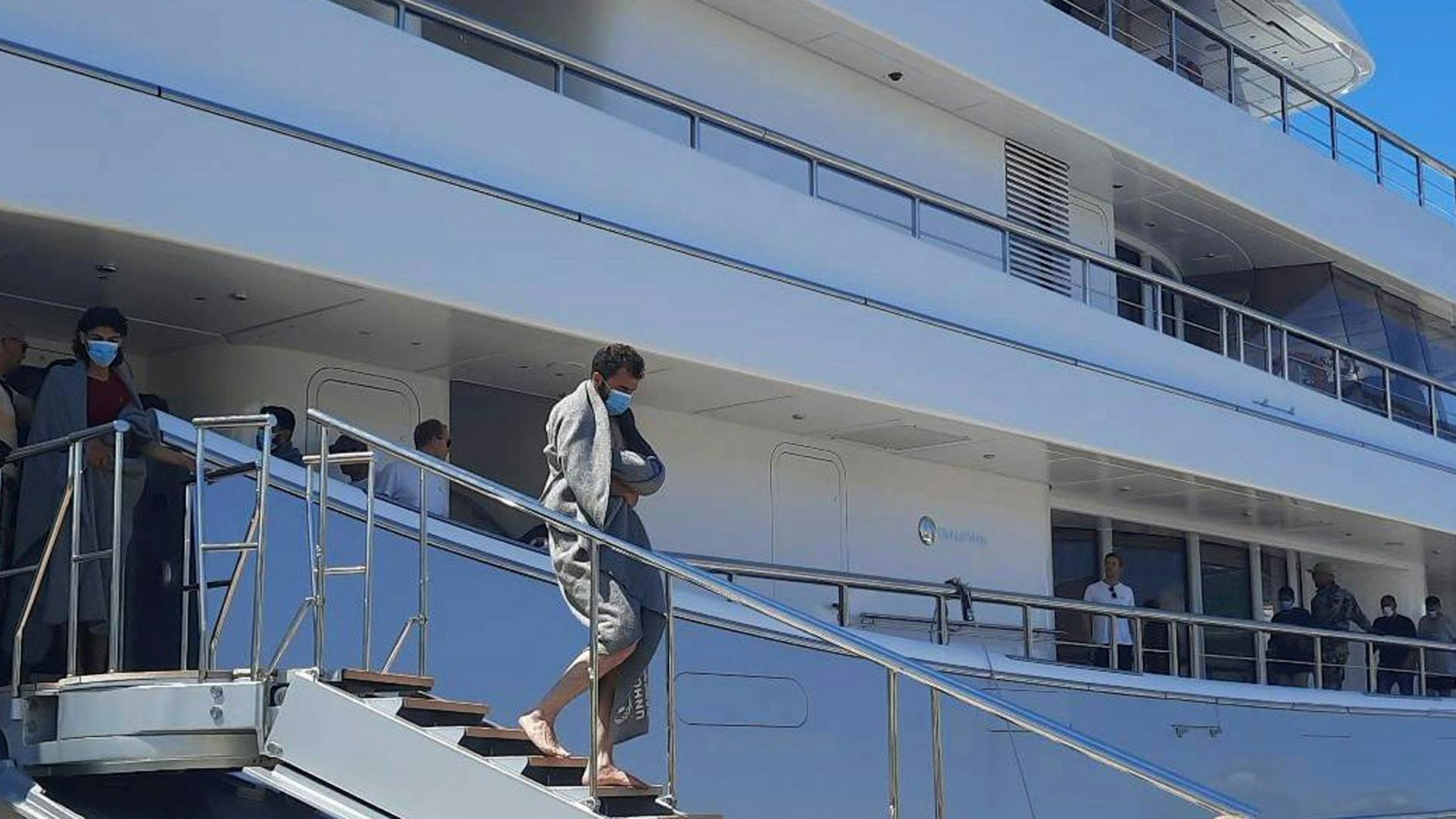 In eine Decke gehüllt, verlässt ein Flüchtling die Jacht Mayan Queen. Das Luxusschiff eines mexikanischen Milliardärs hatte viele Schiffbrüchige geborgen.