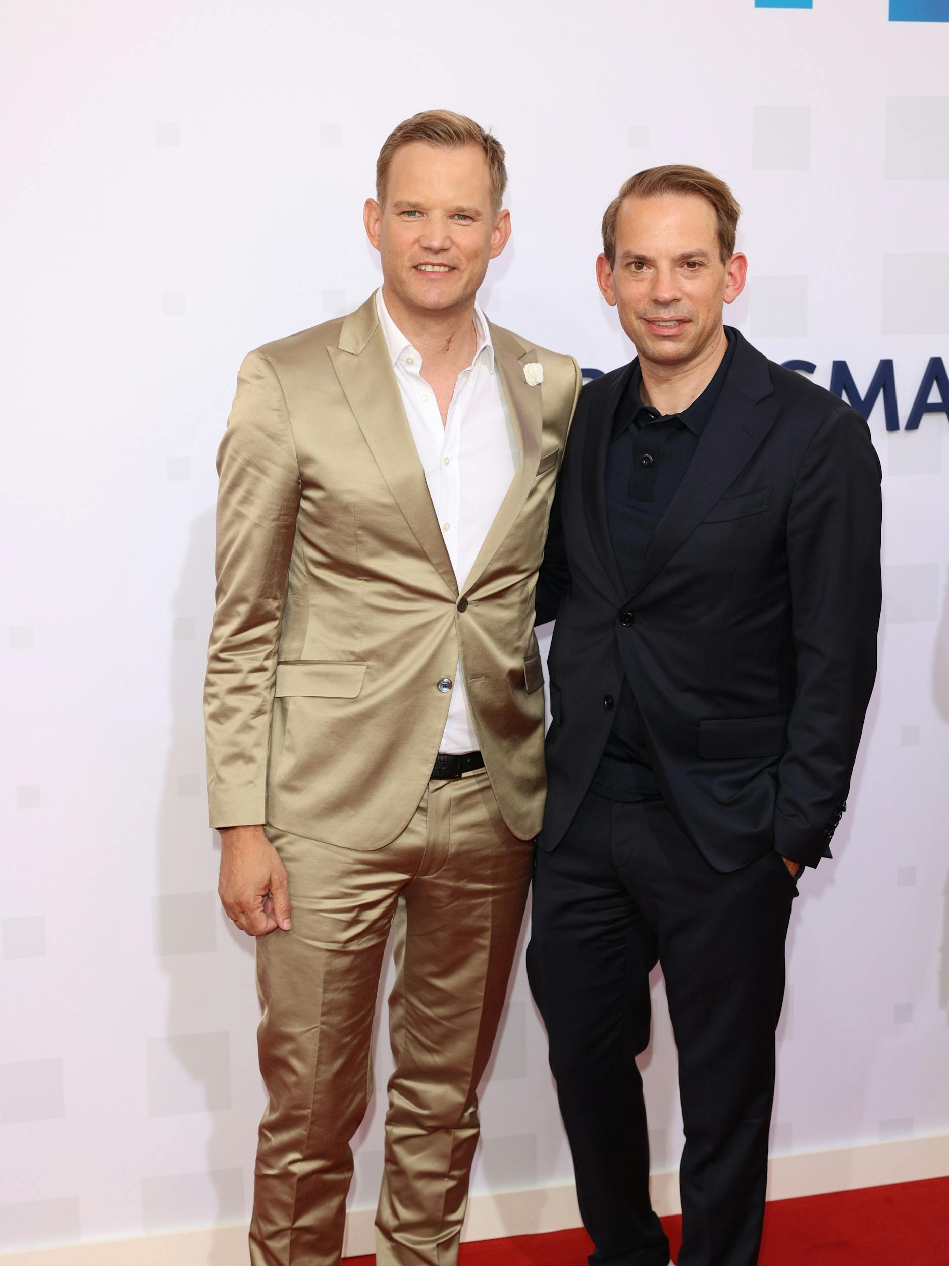 „Dr. Corona“ Hendrik Streeck (l.) und Ehemann Paul Zubeil zeigen sich auf dem roten Teppich der Bertelsmann-Party 2023.