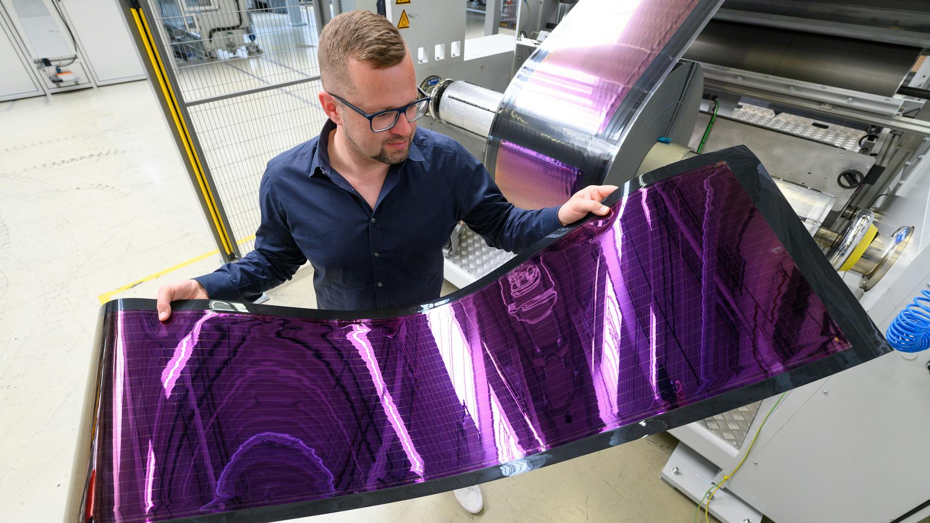 Stephan Kube vom Dresdner Solarunternehmens Heliatek hält in einer Produktionshalle biegsame, organische Solarfolie in den Händen. Mit solchen Produkten hat Europa noch einen Technologievorsprung.