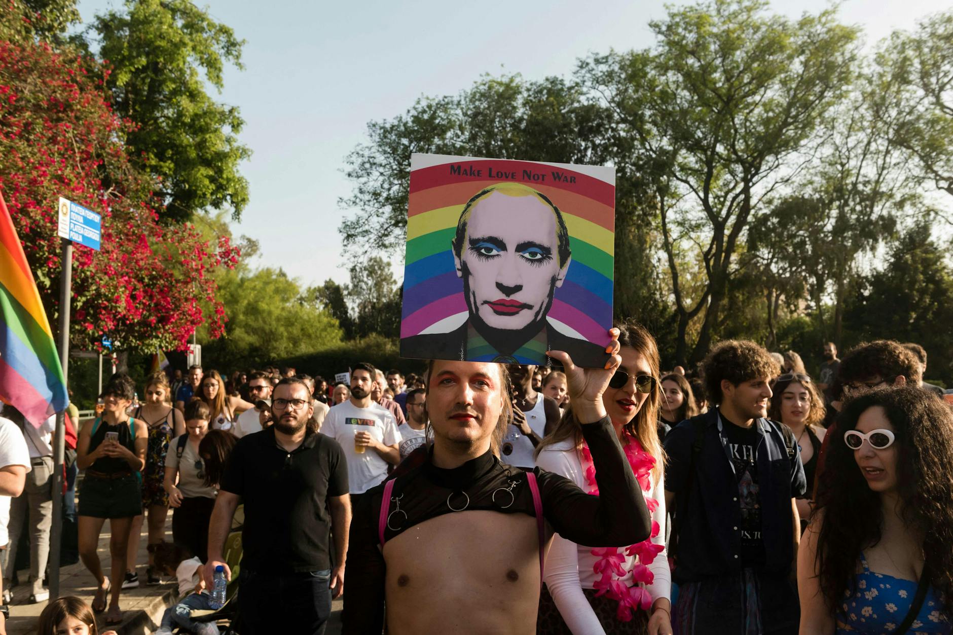 Ein Teilnehmer der jährlichen Gay-Pride-Parade in Nikosia hält am 27. Mai 2023 ein Bild des russischen Präsidenten Wladimir Putin vor einem Regenbogen hoch.