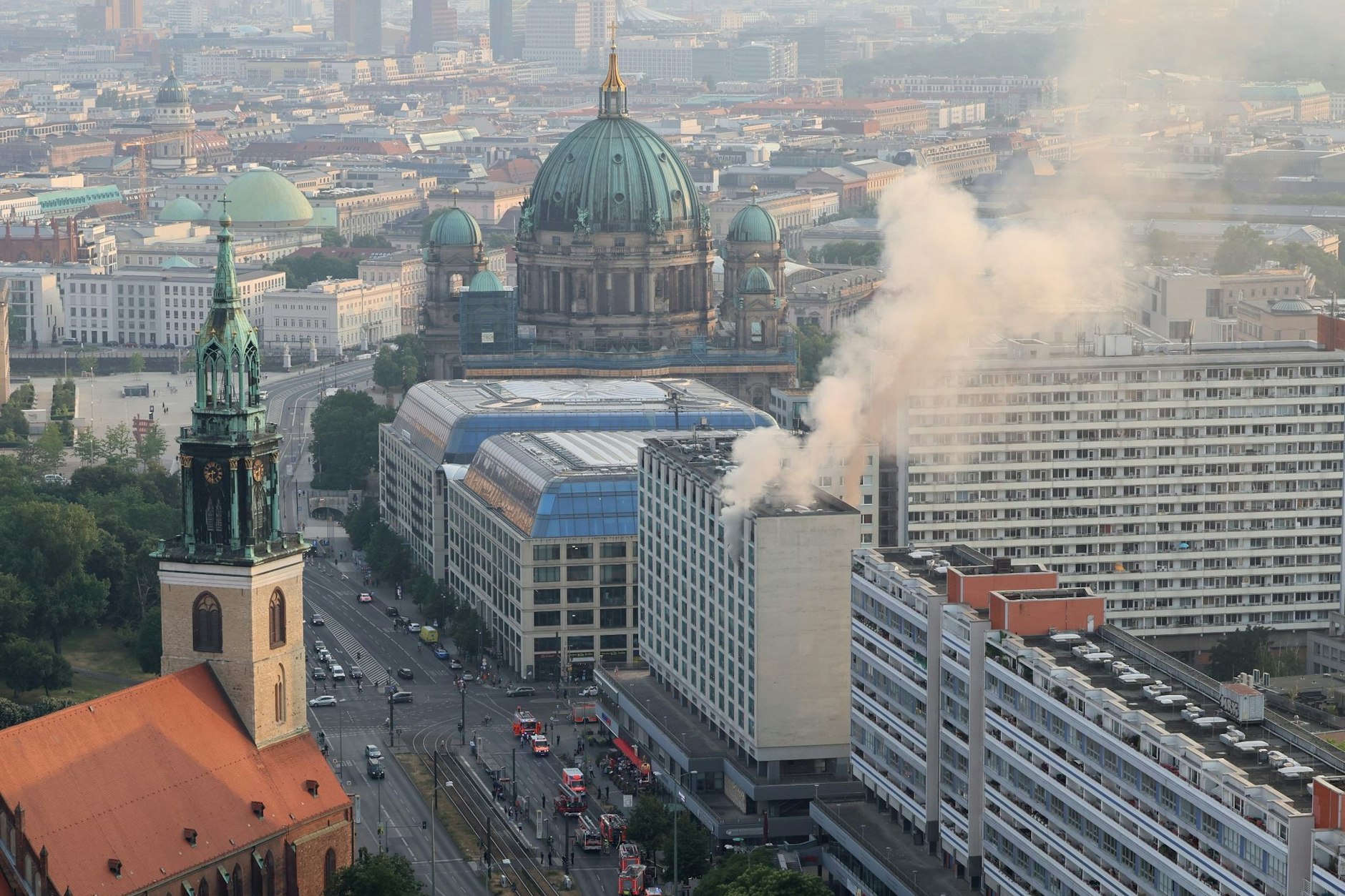 Rauch steigt aus einem Hochhaus an der Karl-Liebknecht-Straße. Im Hintergrund ist der Berliner Dom zu sehen.&nbsp;