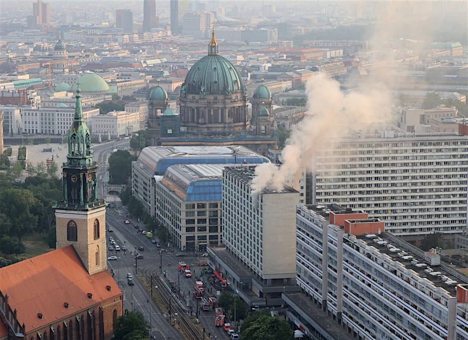 Rauch steigt aus einem Hochhaus an der Karl-Liebknecht-Straße. Im Hintergrund ist der Berliner Dom zu sehen.&nbsp;