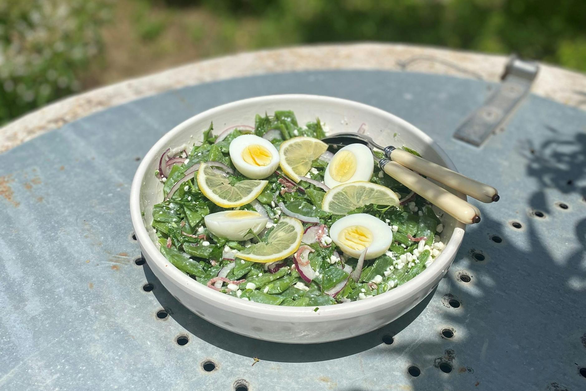 Brechbohnensalat mit Cottage-Cheese, einer Speck-Zwiebel-Vinaigrette und Gartenkräutern.