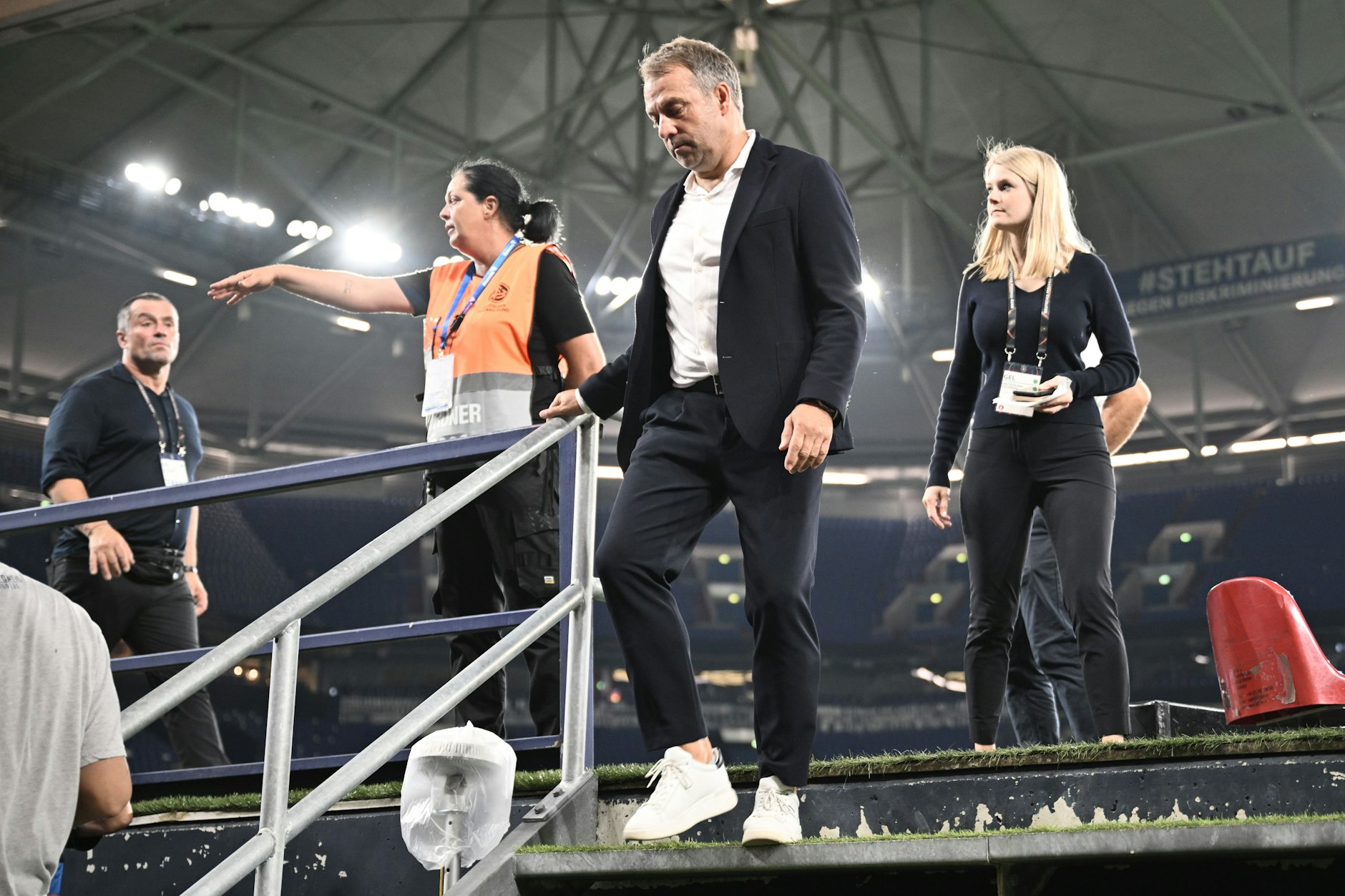 Abwärts geht es unter Hansi Flick mit der Nationalmannschaft. Der Bundestrainer schaut dabei genau auf die Stufen, damit er nicht ins Stolpern kommt.