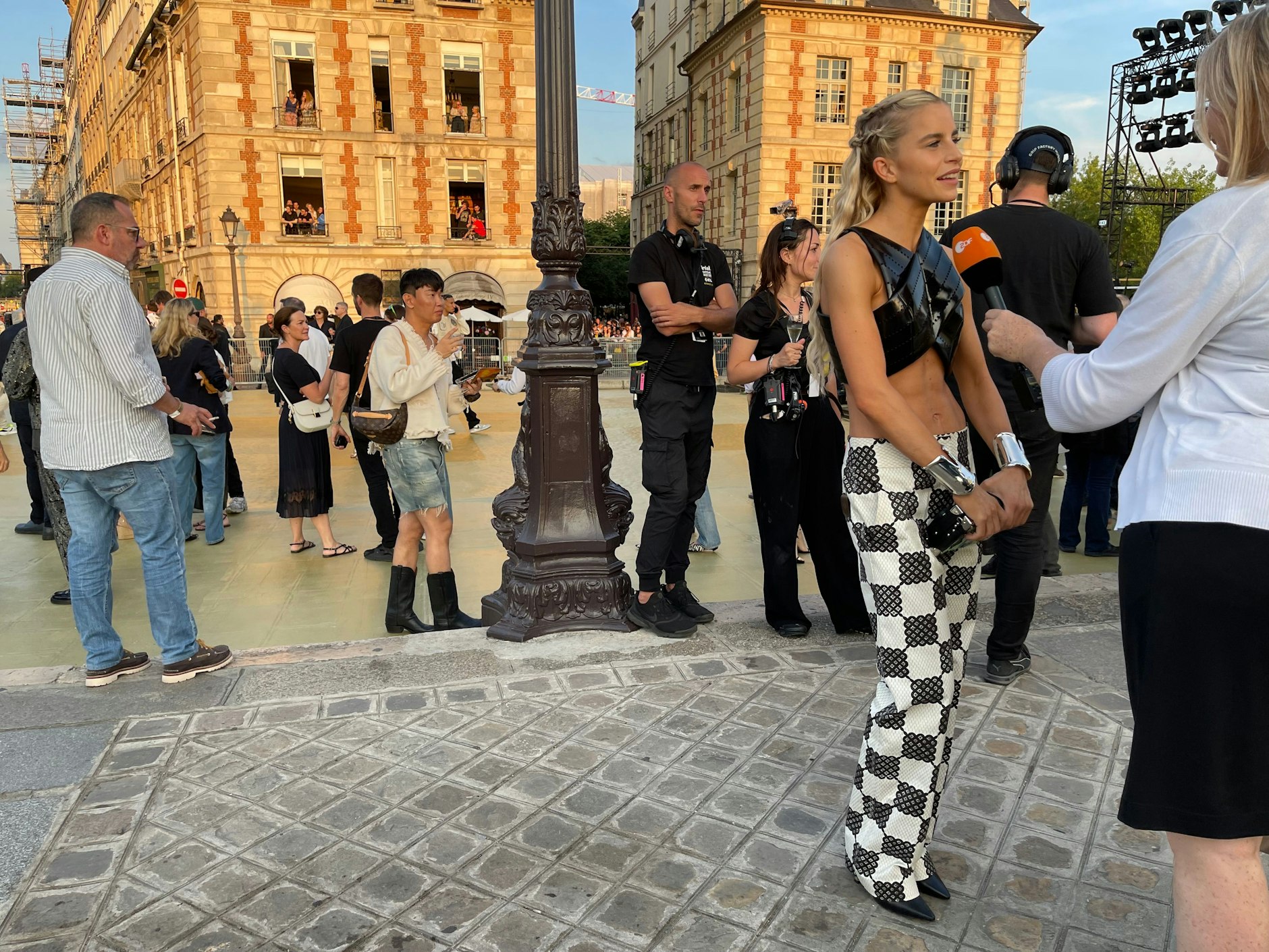 Im Hintergrund sieht man, wie sich die Menschen an den Fenstern drängen, um die Show auf der Brücke zu sehen. Vorne rechts gibt die deutsche Influencerin Caro Daur ein Interview.