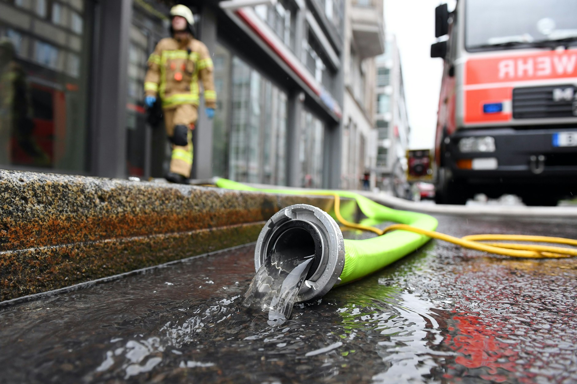 Feuerwehrleute pumpen in Berlin-Mitte Wasser aus einem Keller.