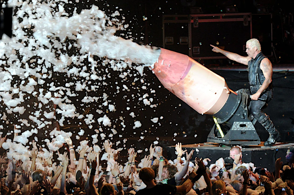 Rammstein-Frontmann Till Lindemann bespritzt mit einer Schaumkanone das Publikum.