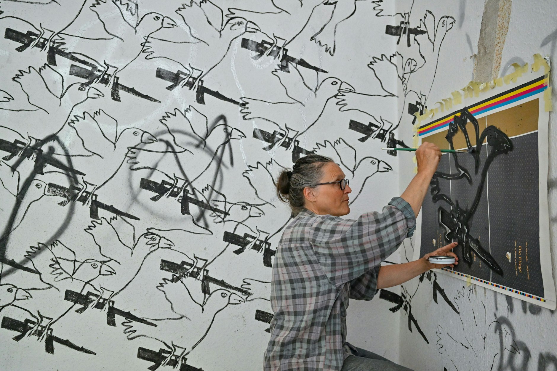 Antje Scholz, Künstlerin aus dem Oderbruch, zeichnet ihr Kunstwerk „Friedensbringer“ an eine Wand im Schlossgut Finowfurt.