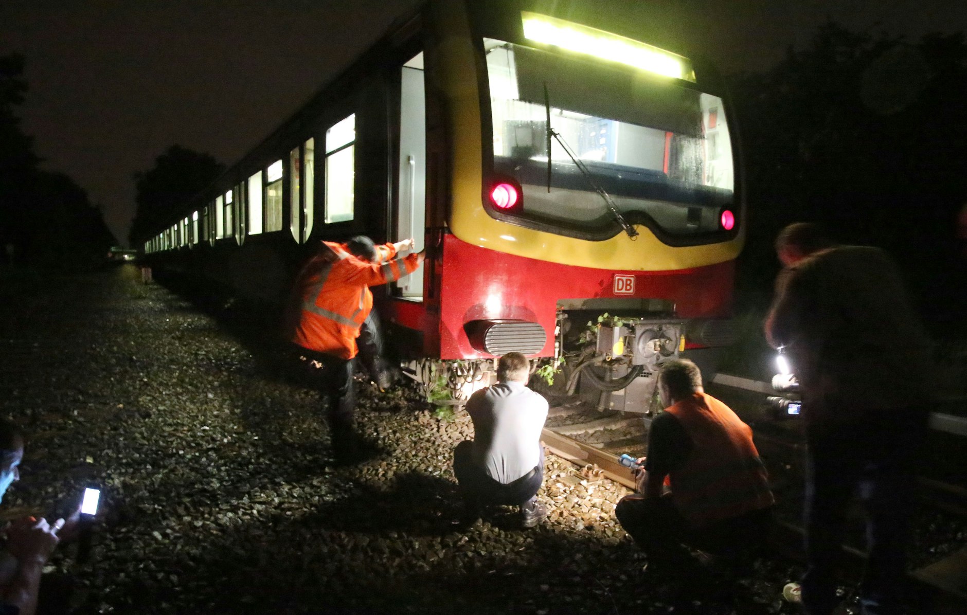 Mitarbeiter der Bahn untersuchen einen S-Bahnzug, der bei heftigem Unwetter aus den Schienen gesprungen ist.