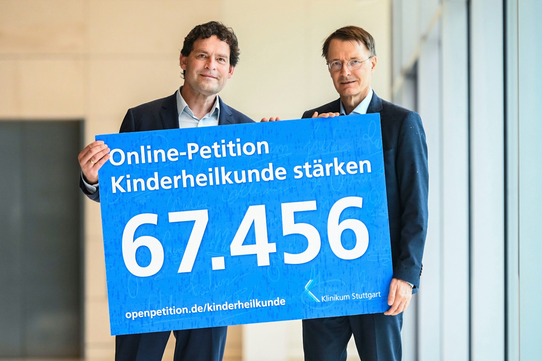 Steffen Jürgens überreicht symbolisch die Petition an Karl Lauterbach.