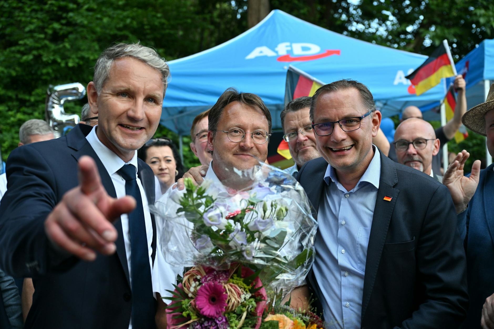 Sonneberg: Björn Höcke (li.) und der AfD-Bundesvorsitzende Tino Chrupalla (re.) gratulieren Wahlsieger Robert Sesselmann im Garten eines Restaurants. 