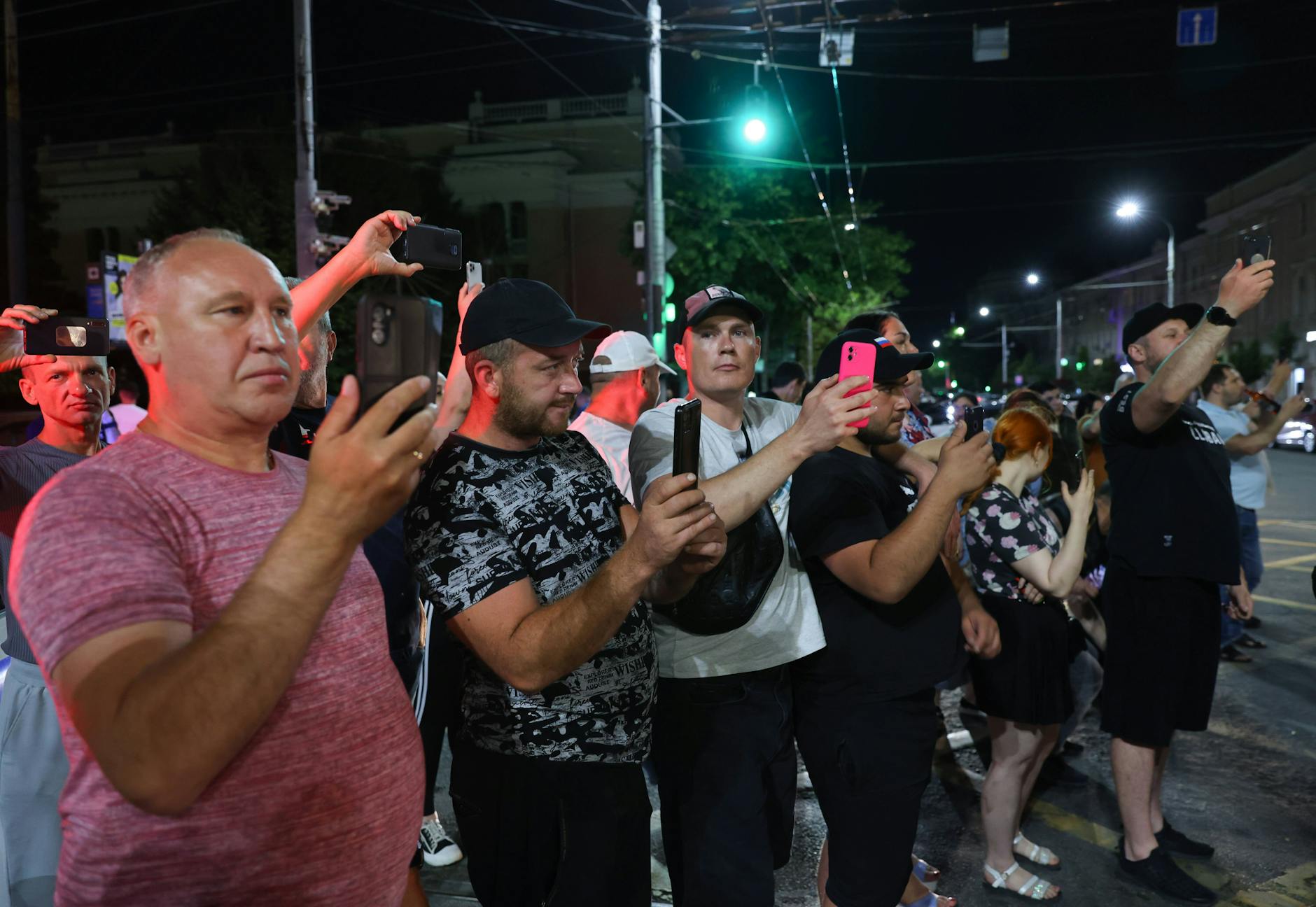 Schaulustige filmen Wagner-Kämpfer mit ihren Smartphones.