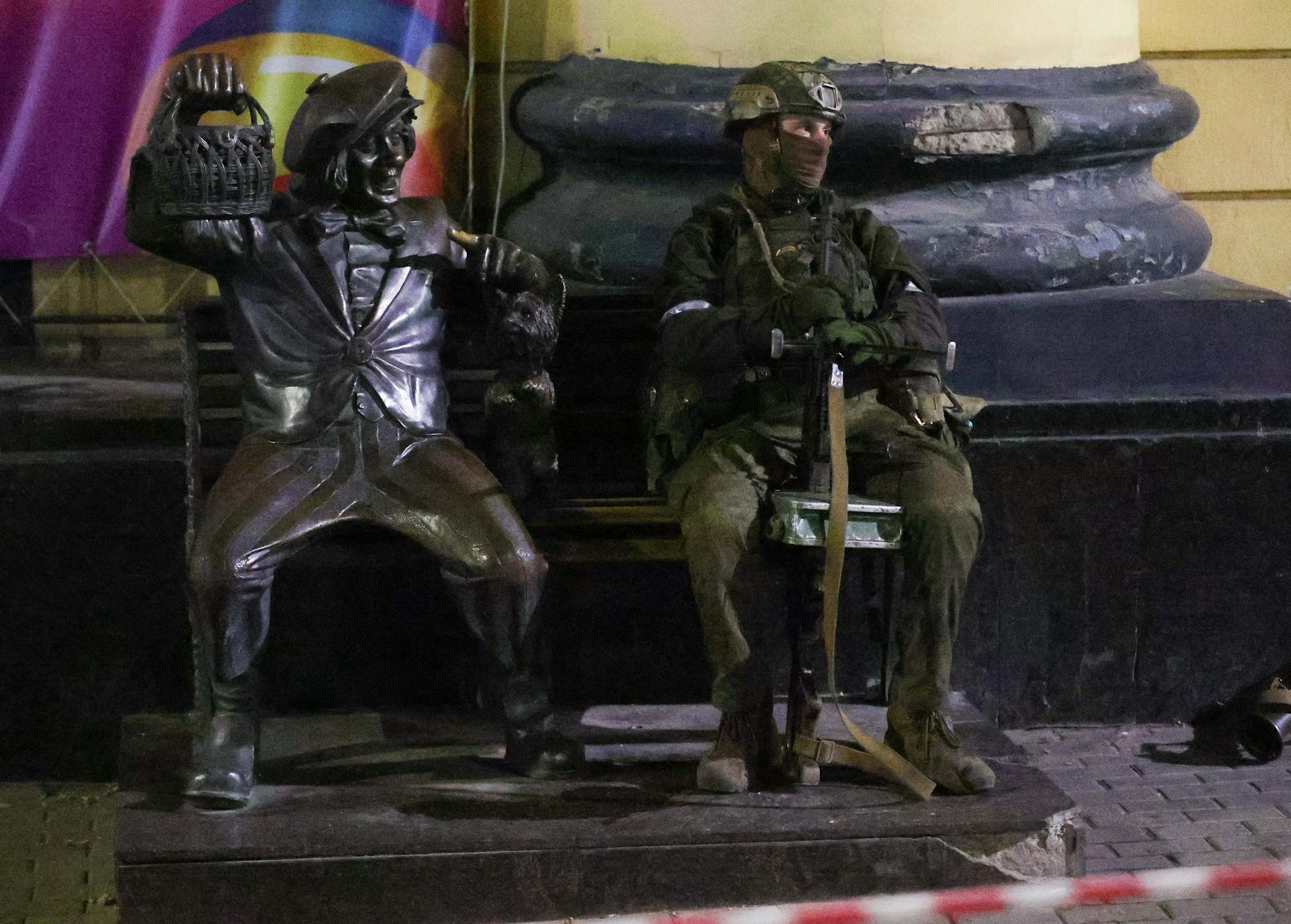 Ein Wagner-Kämpfer sitzt neben einer Skulptur des Clowns Oleg Popow.