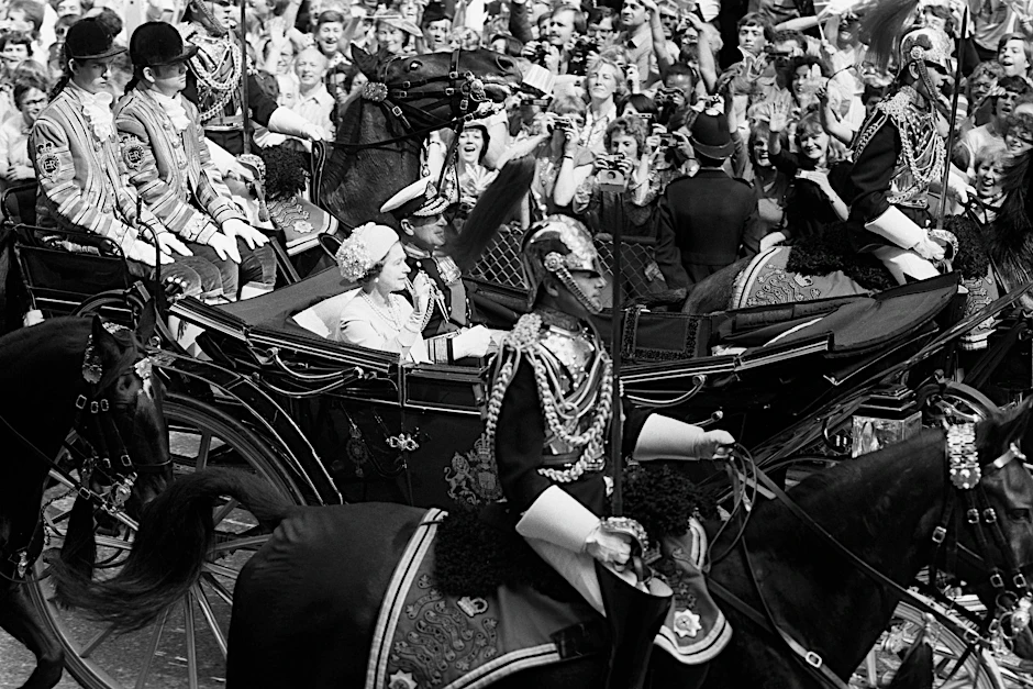 ARCHIV - Die Königin und der Herzog von Edinburgh fahren anlässlich der Hochzeit des Prinzen von Wales und Lady Diana Spencer die Fleet Street entlang. Mit dabei: der ehemalige Lakai Paul Whybrew (ganz links).  