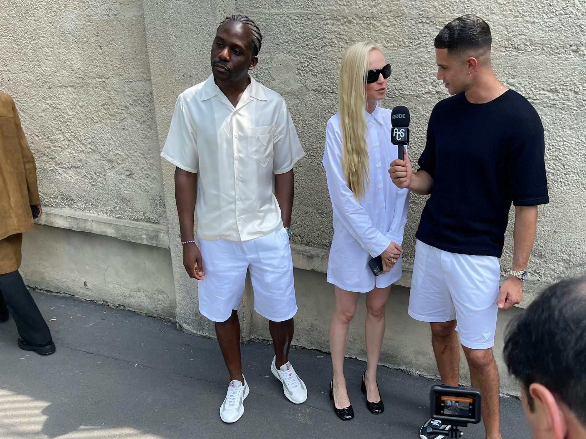 Eine Dame wird nach der Präsentation der Prada-Männerkollektion für den Sommer 2024 nach ihrer Meinung gefragt. Später landen die Aufnahmen in Form von Reels auf Instagram und TikTok.