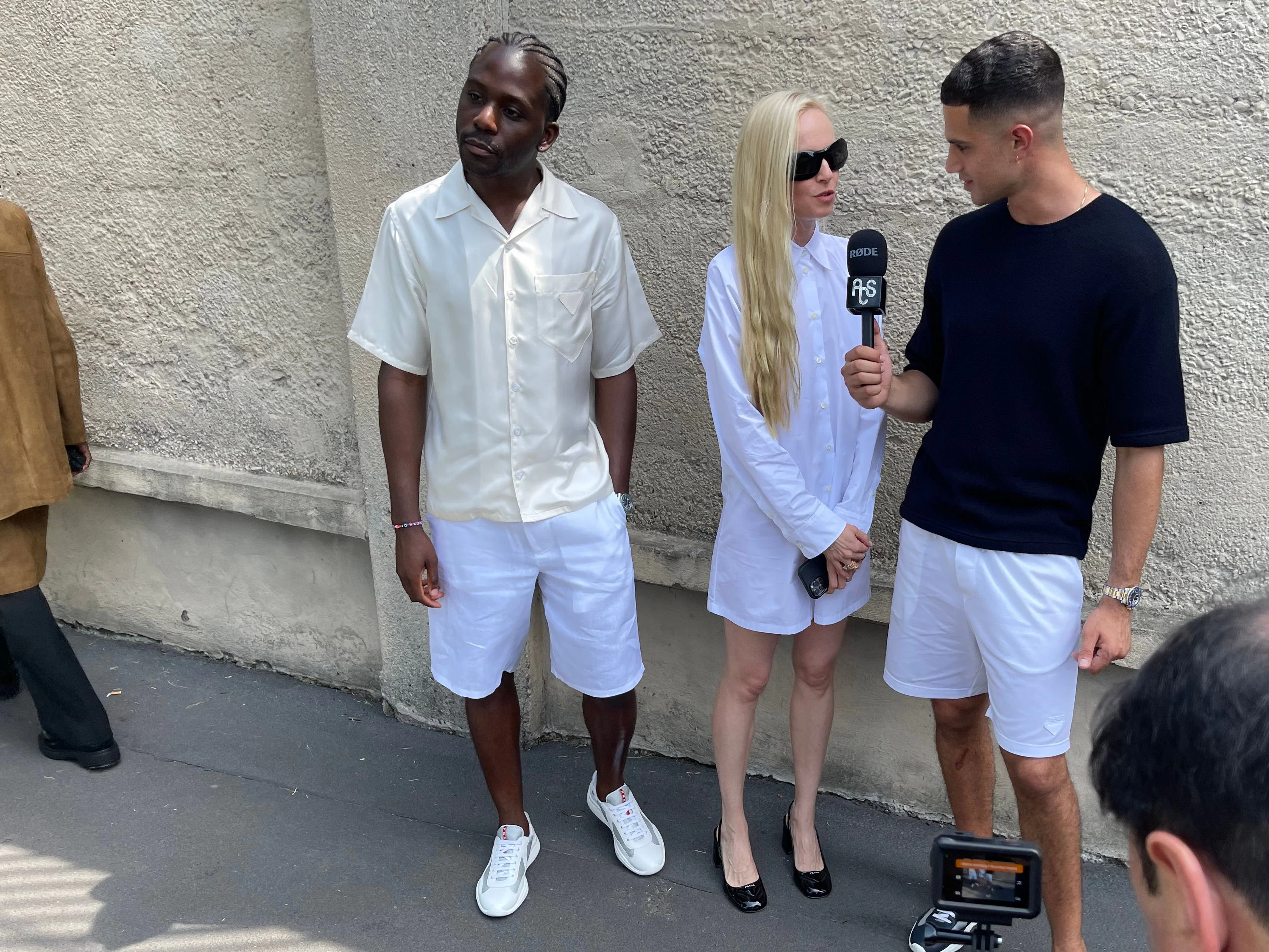 Eine Dame wird nach der Präsentation der Prada-Männerkollektion für den Sommer 2024 nach ihrer Meinung gefragt. Später landen die Aufnahmen in Form von Reels auf Instagram und TikTok.
