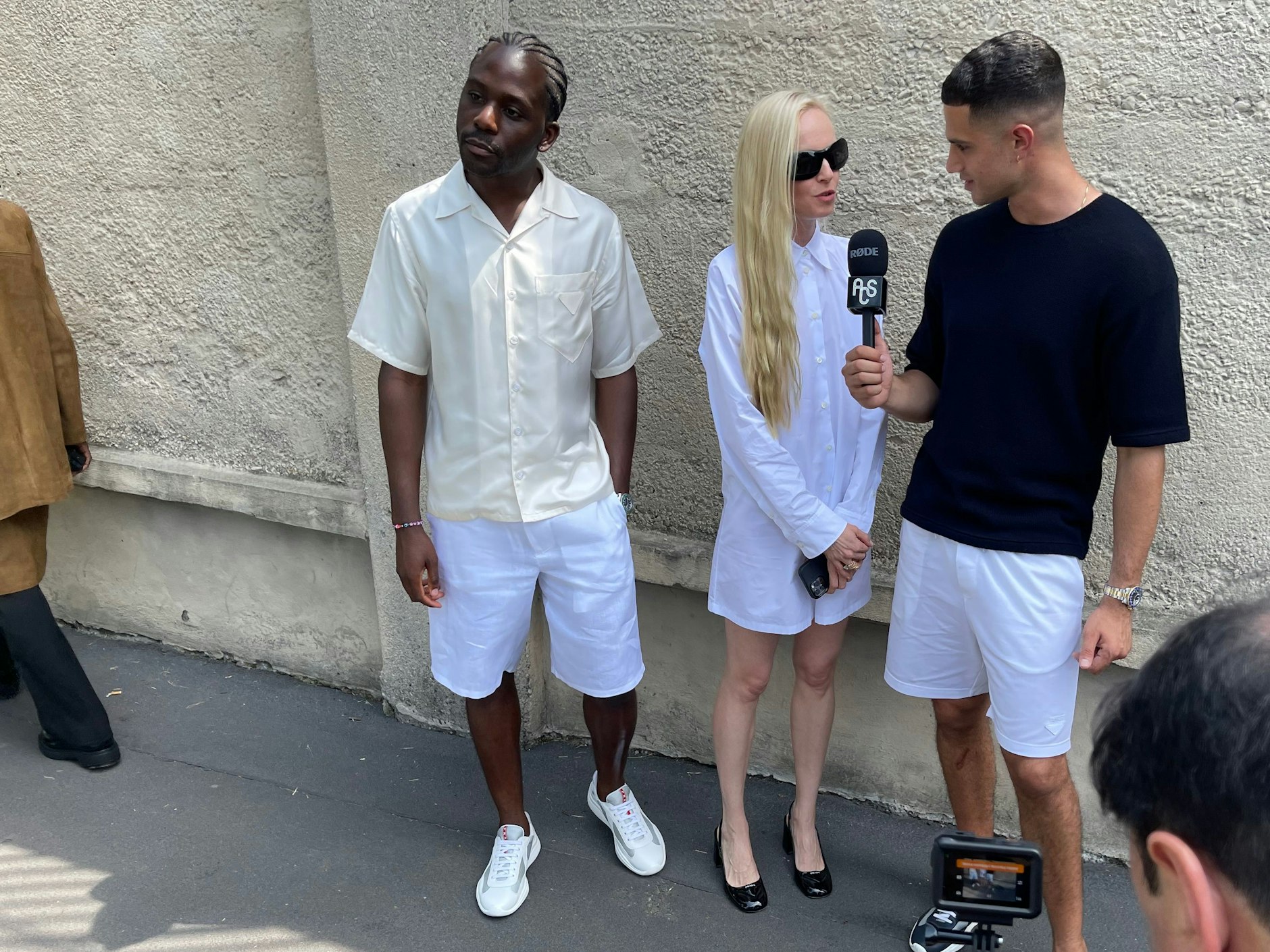 Eine Dame wird nach der Präsentation der Prada-Männerkollektion für den Sommer 2024 nach ihrer Meinung gefragt. Später landen die Aufnahmen in Form von Reels auf Instagram und TikTok.