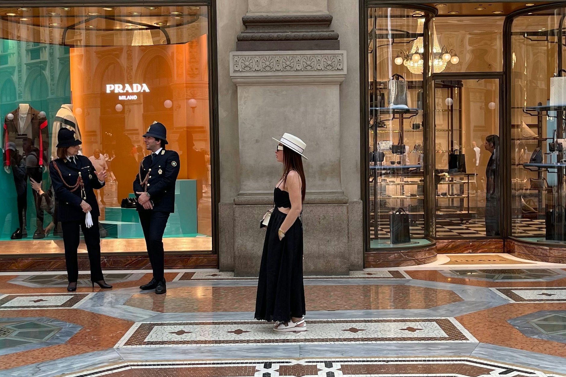 Frau mit Hut vor dem Prada-Store - und die Kollegen der Vigili Urbani, des italienischen Ordnungsamtes, sind in schicken Uniformen anwesend. Die Dame trägt im Dienst sogar hohe Schuhe.