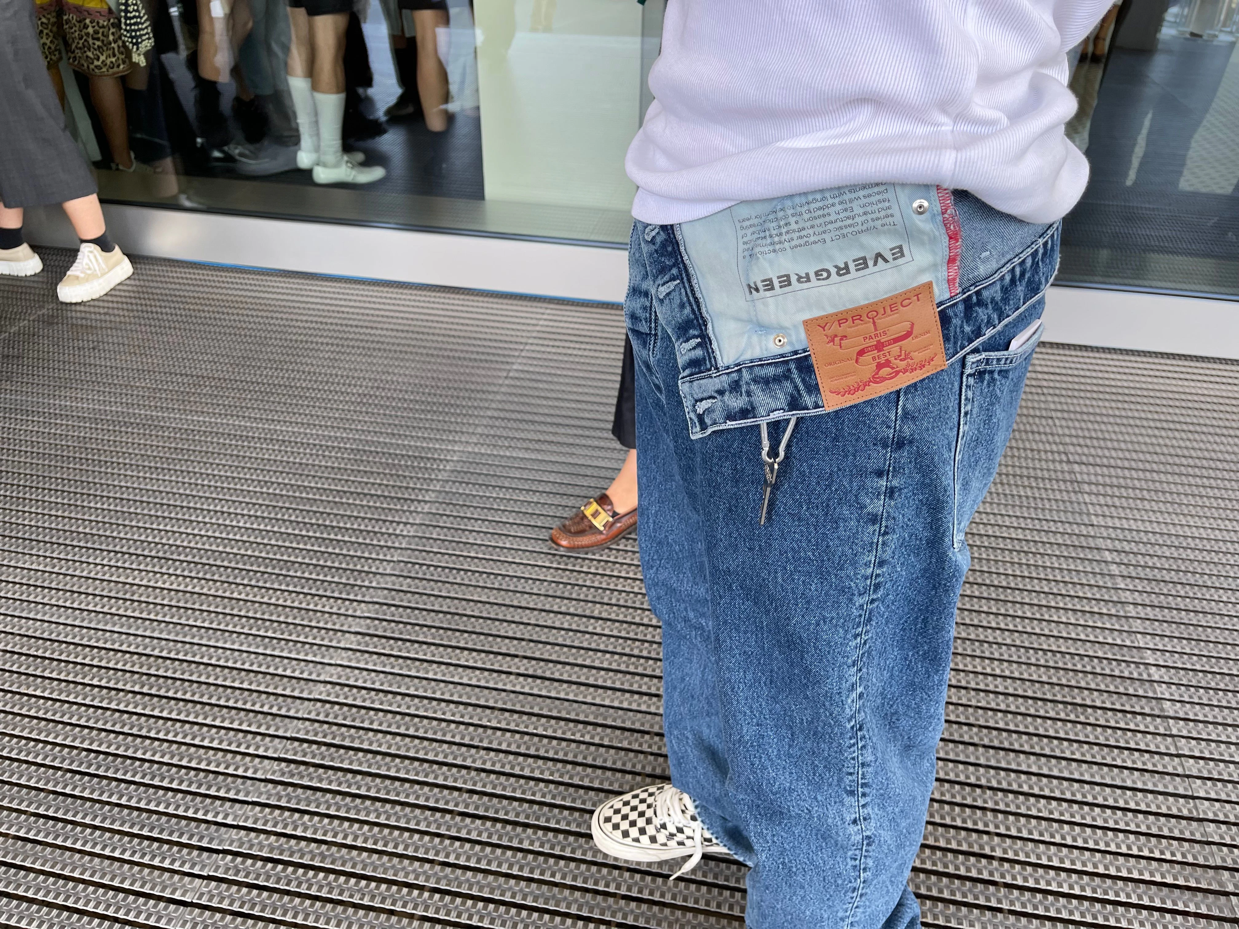 Ein Show-Gast erscheint in einer Jeans mit asymmetrischem Bund von Y/Project. Creative Director der Pariser Marke ist Glenn Martens, der seit 2021 auch die kreative Leitung bei Diesel übernommen hat.