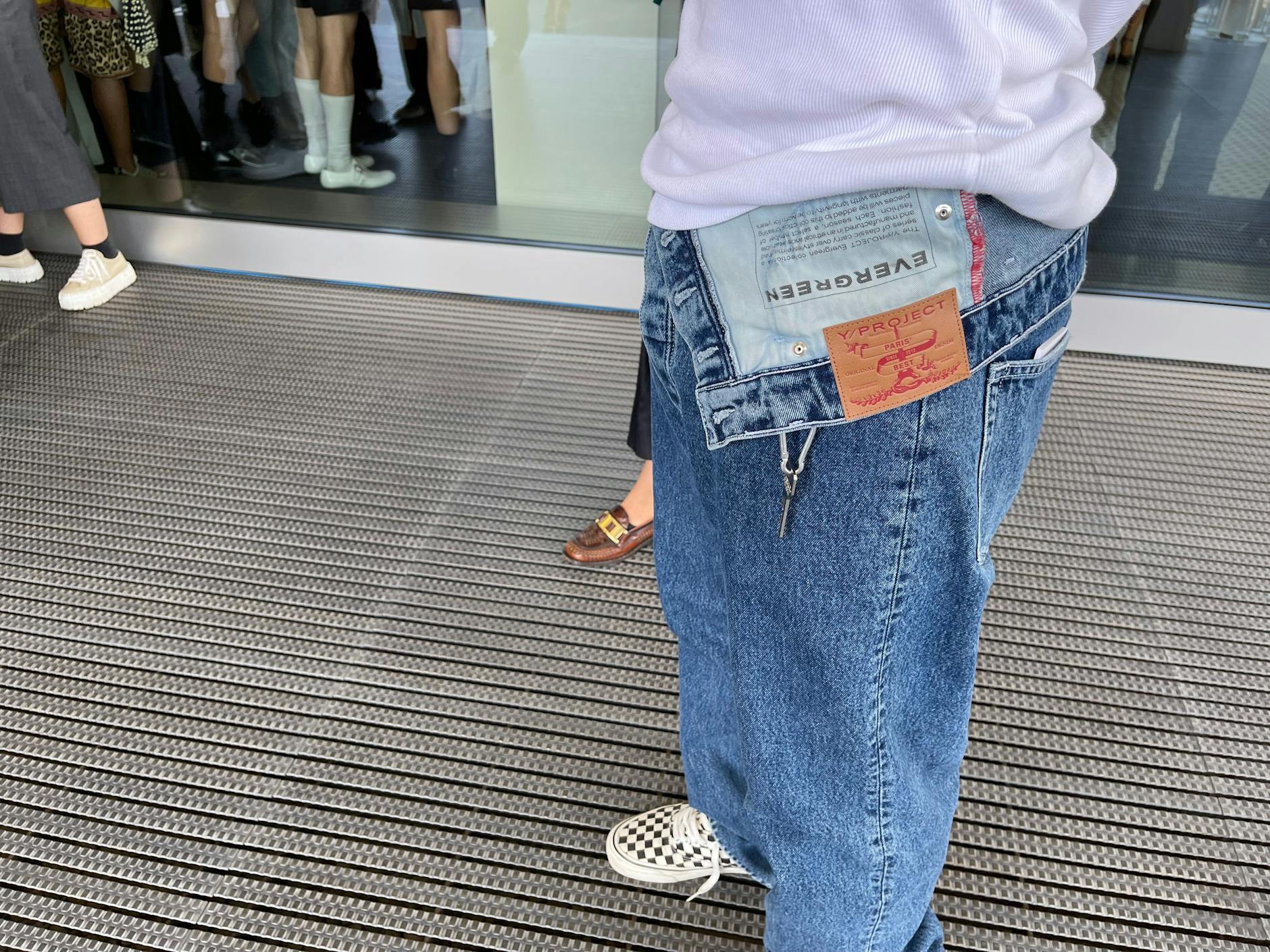 Ein Show-Gast erscheint in einer Jeans mit asymmetrischem Bund von Y/Project. Creative Director der Pariser Marke ist Glenn Martens, der seit 2021 auch die kreative Leitung bei Diesel übernommen hat.