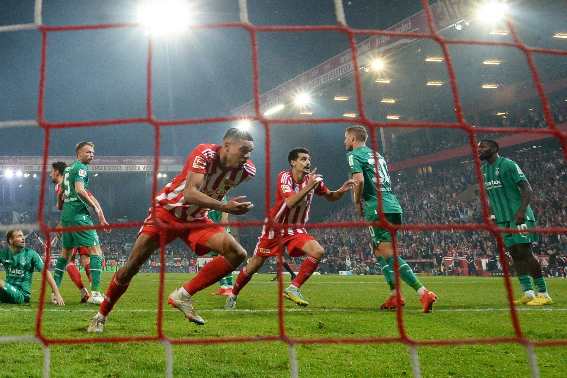 Ab zum späten Jubel: Danilho Doekhi (l.) hat den späten Siegtreffer für den 1. FC Union Berlin gegen Borussia Mönchengladbach erzielt und läuft zu den Fans.