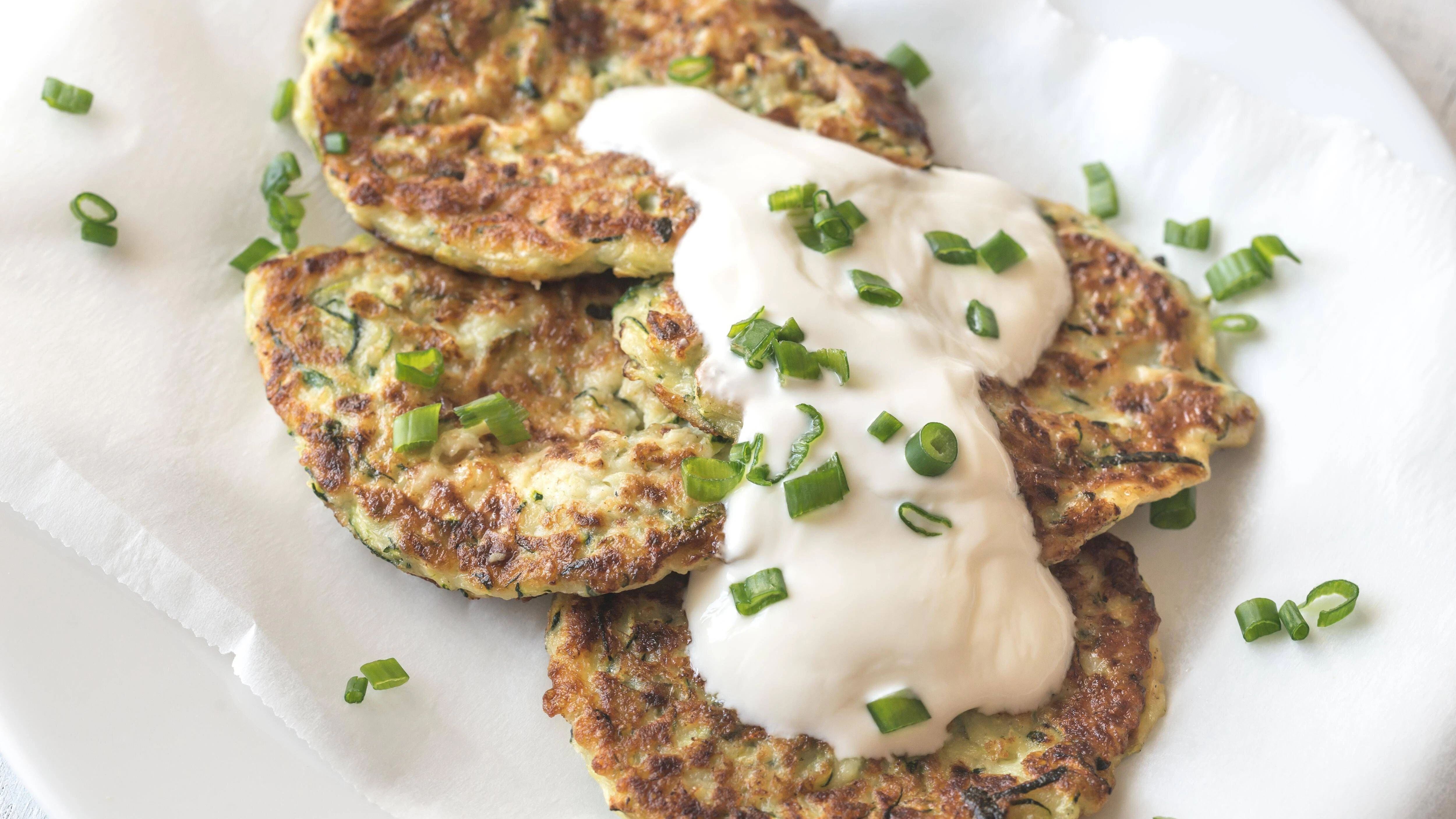 Zucchini-Pfannkuchen mit Feta kann man mit einem Dip als Hauptgericht servieren. 