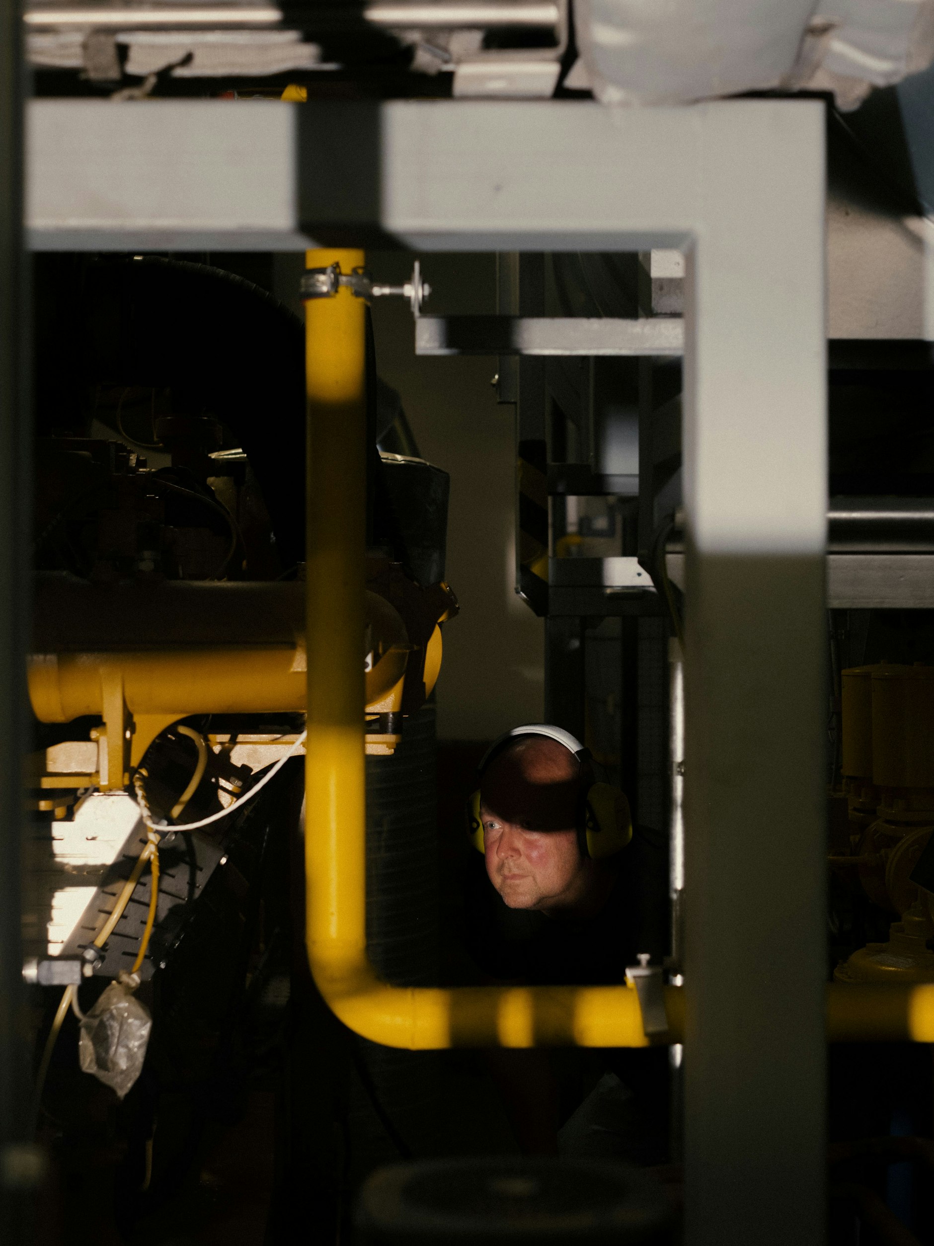 Dirk Nielsen, Betriebsleiter Elektrotechnik, prüft einige Rohre des Blockheizkraftwerks im Martin-Luther-Krankenhaus.