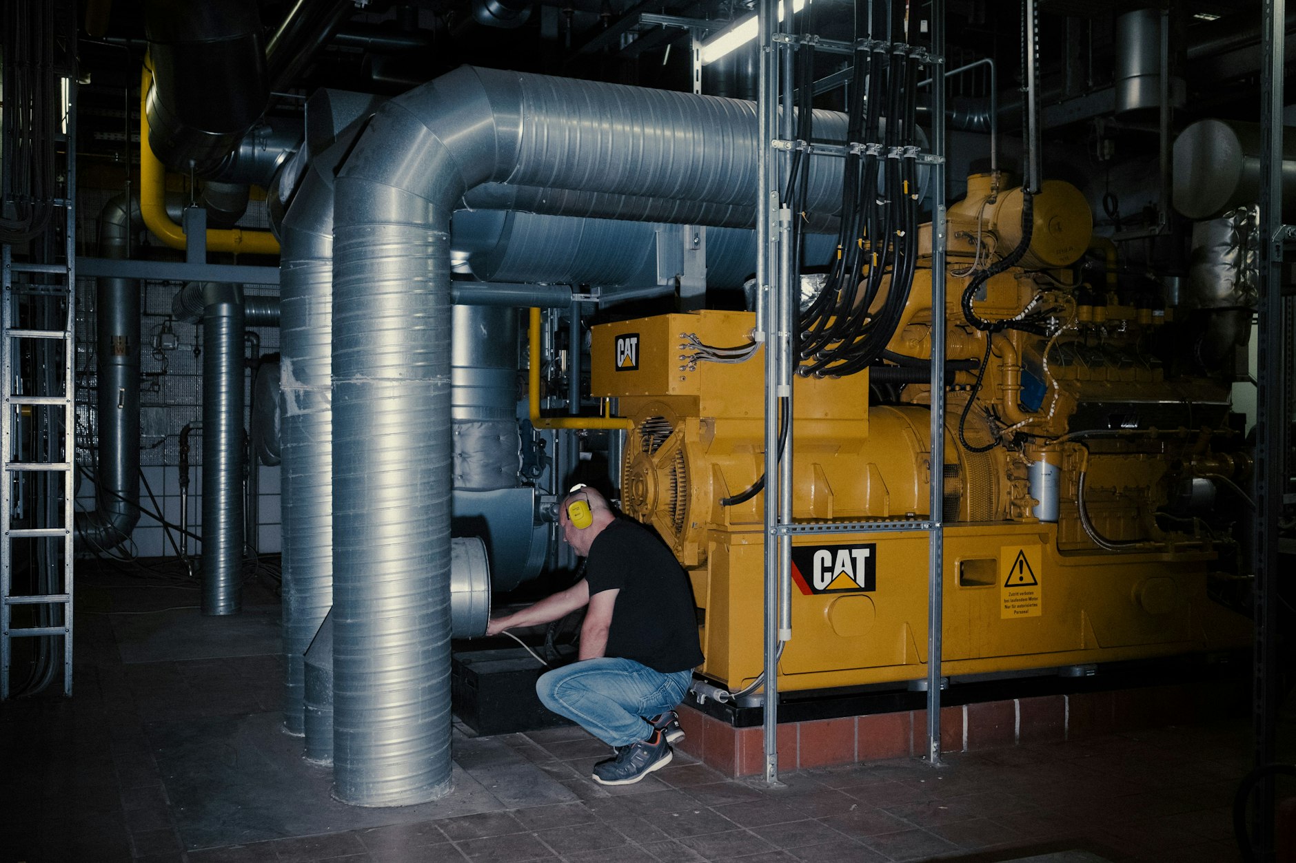 Dirk Nielsen (Electrical engineering foreman) checking some pipes of the combined heat and power plant at the Martin-Luther Hospital, Berlin Wilmersdorf - 21.07.2023

Dirk Nielsen (Betriebsmeister Elektrotechnik) checking some pipes of the Blockheizkraftwerk at the Martin-Luther Krankenhaus, Berlin Wilmersdorf - 21.07.2023