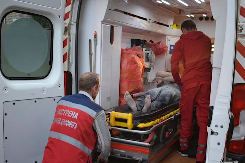 HANDOUT - Sanitäter bereiten in Kramatorsk den Transport eines verletzten Mannes in eine naheliegende Klinik vor.  a