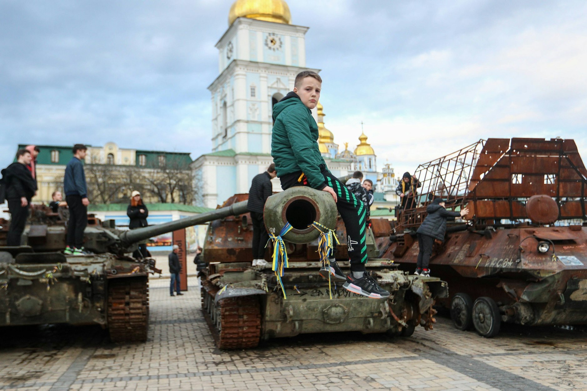 Kinder setzen auf zerstörten Panzern in Kiew. 