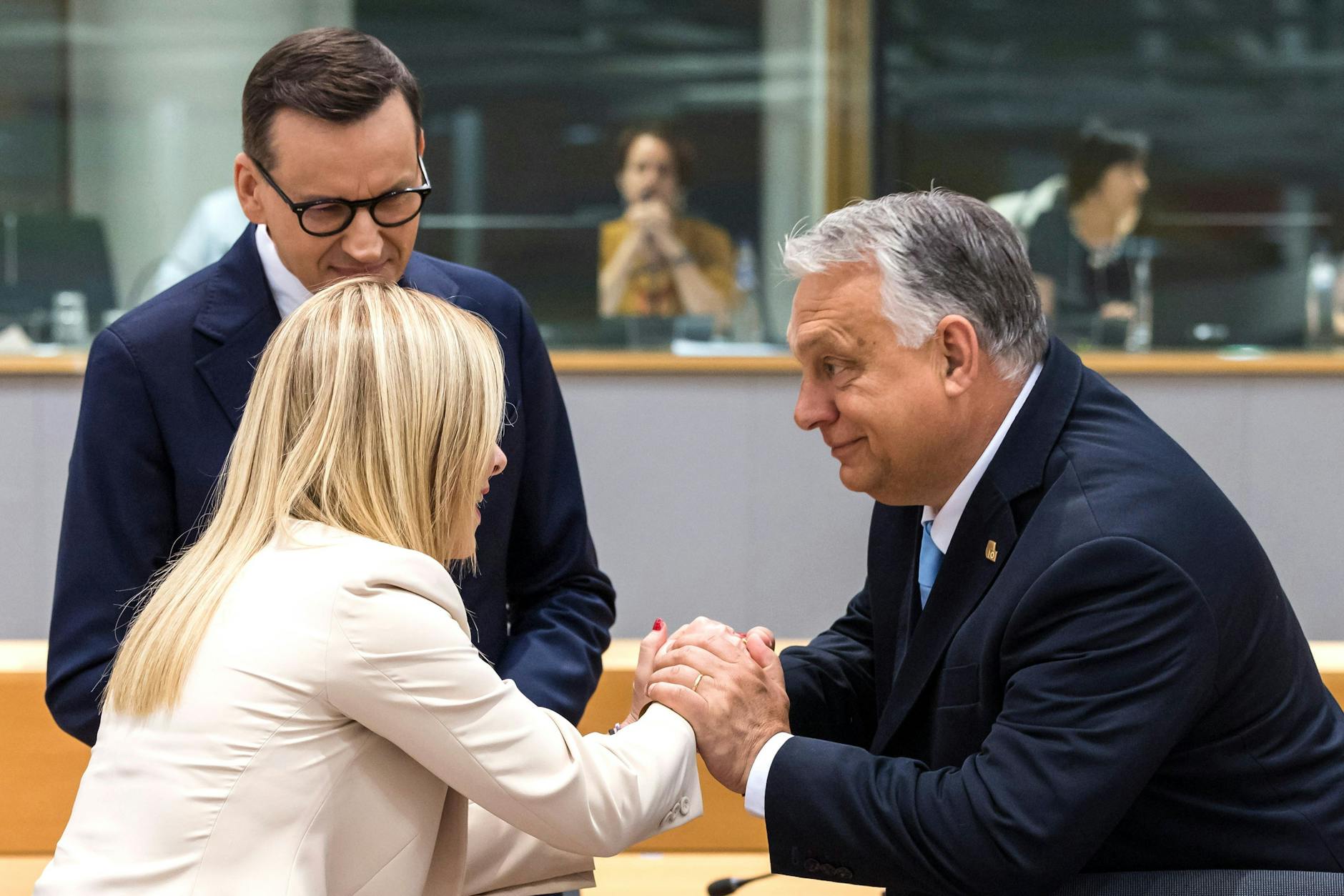 Viktor Orbán (r), Ministerpräsident von Ungarn, spricht mit Giorgia Meloni (l), Ministerpräsidentin von Italien, und Mateusz Morawiecki (hinten), Ministerpräsident von Polen, beim EU-Asylgipfel. 