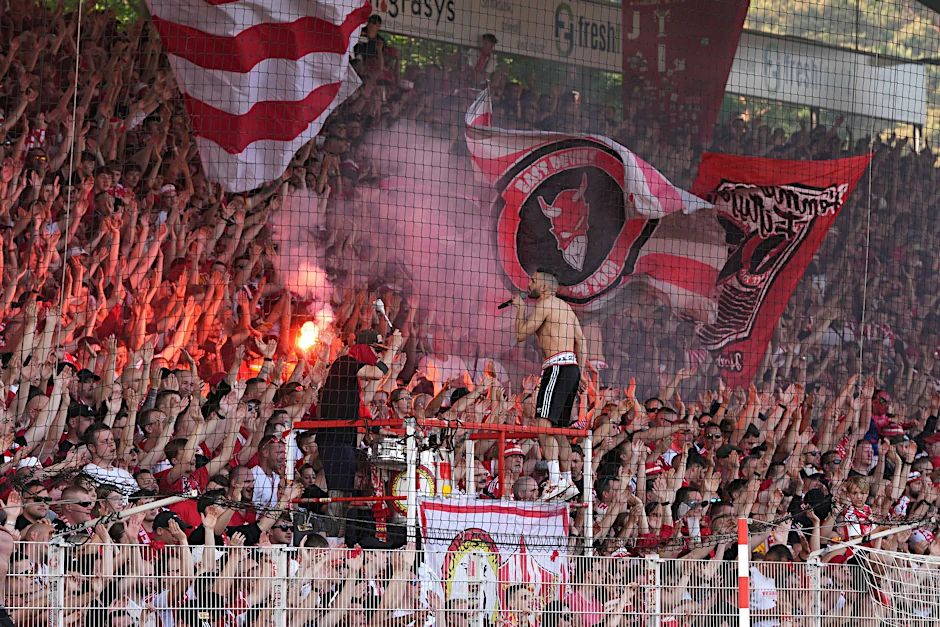 ARCHIV - Fans von Union jubeln nach Spielende und zünden Pyrotechnik.  