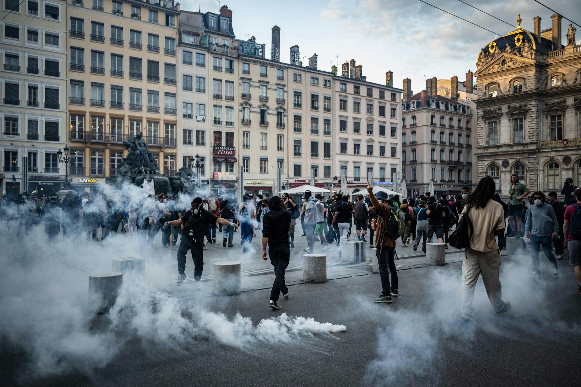 Demonstranten sind auf dem Place des Terreaux in Lyon von Tränengas umgeben.