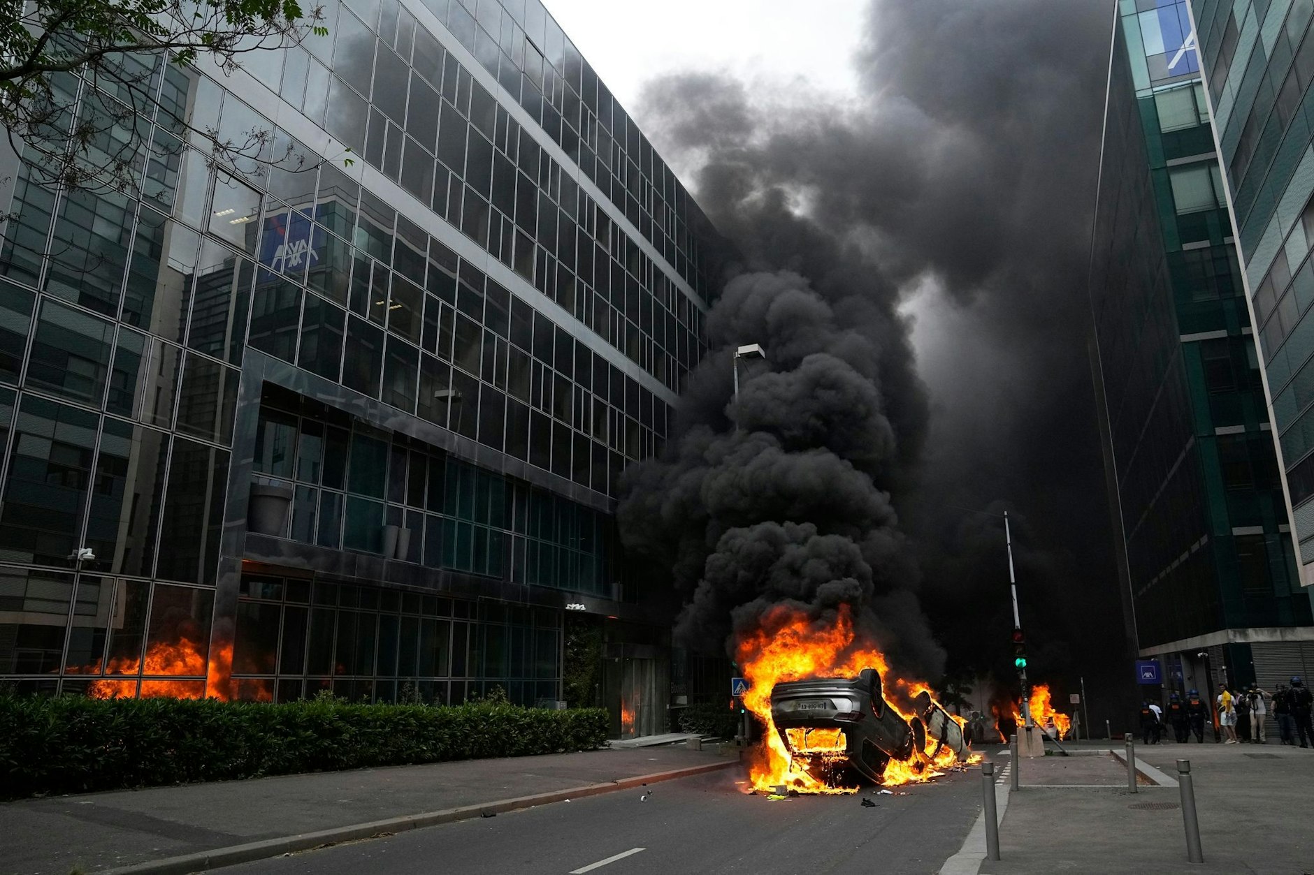 Brennende Autos liegen am Donnerstag nach einem Trauermarsch in Nanterre auf einer Straße.