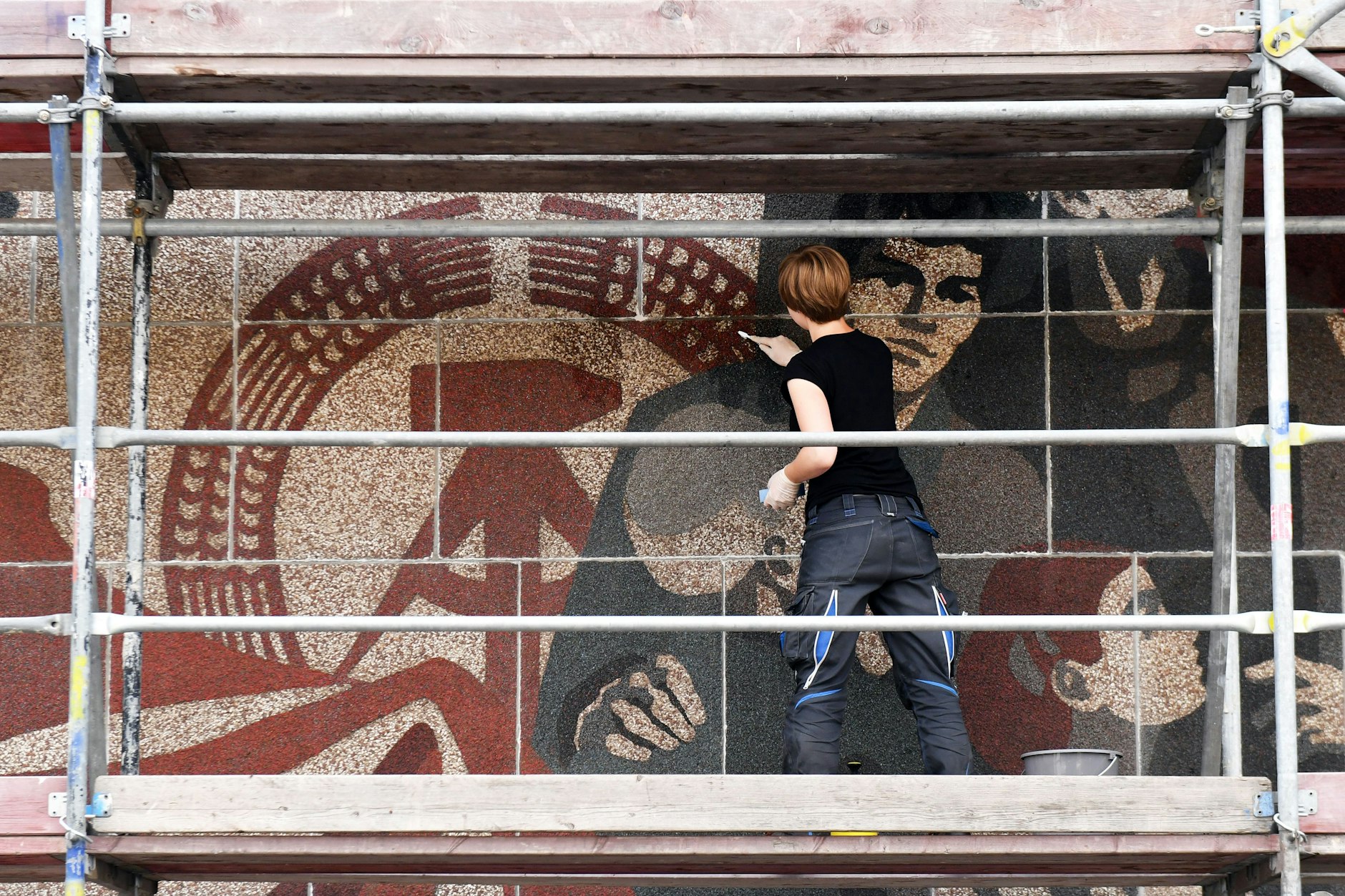 Studentin Eike Stöcker arbeitet am 04.08.2016 in Dresden am Wandbild „Der Weg der roten Fahne“, das sich an der Westfassade am Kulturpalast Dresden befindet.