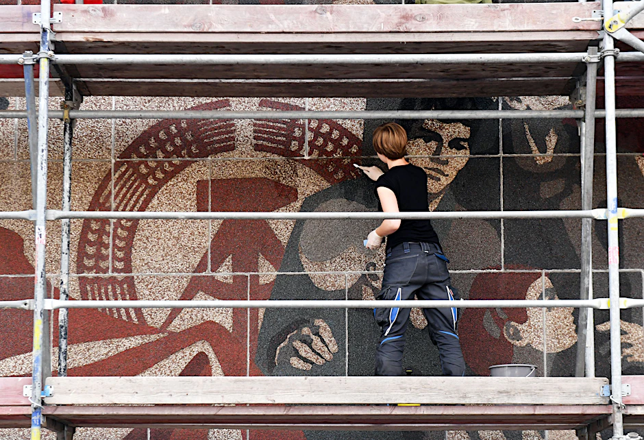Studentin Eike Stöcker arbeitet am 04.08.2016 in Dresden am Wandbild „Der Weg der roten Fahne“, das sich an der Westfassade am Kulturpalast Dresden befindet.