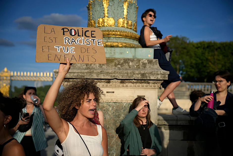 Eine Frau hält am Freitag in Paris ein Plakat mit der Aufschrift «Die Polizei ist rassistisch und tötet Kinder» während einer Demonstration.&nbsp;