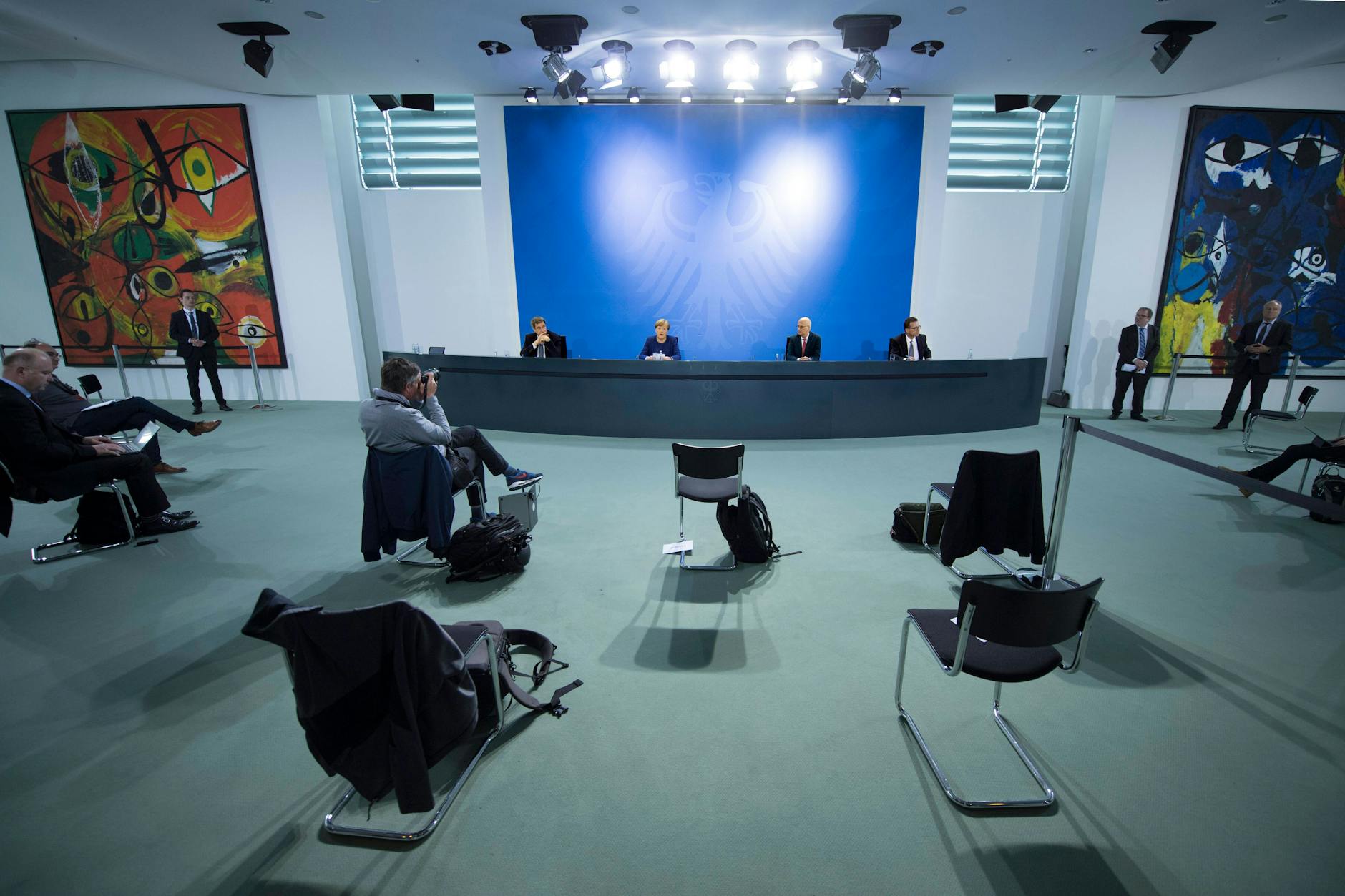 Fotografen und Journalisten verfolgen mit Sicherheitsabstand eine Pressekonferenz im Bundeskanzleramt.