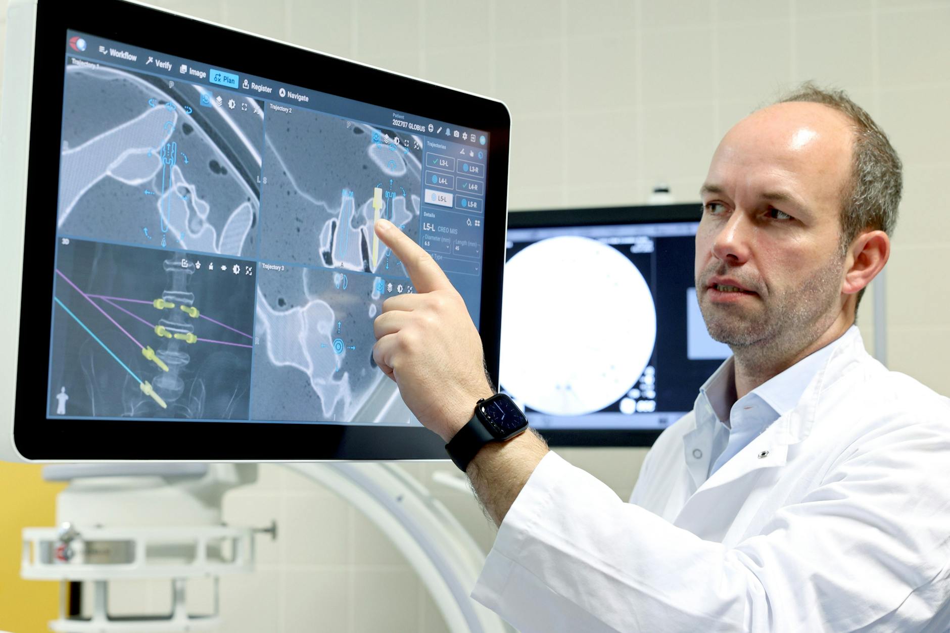 Tim Rumler-von Rüden deutet auf den Roboter-Bildschirm. Die soeben gesetzte Schraube sitzt richtig.