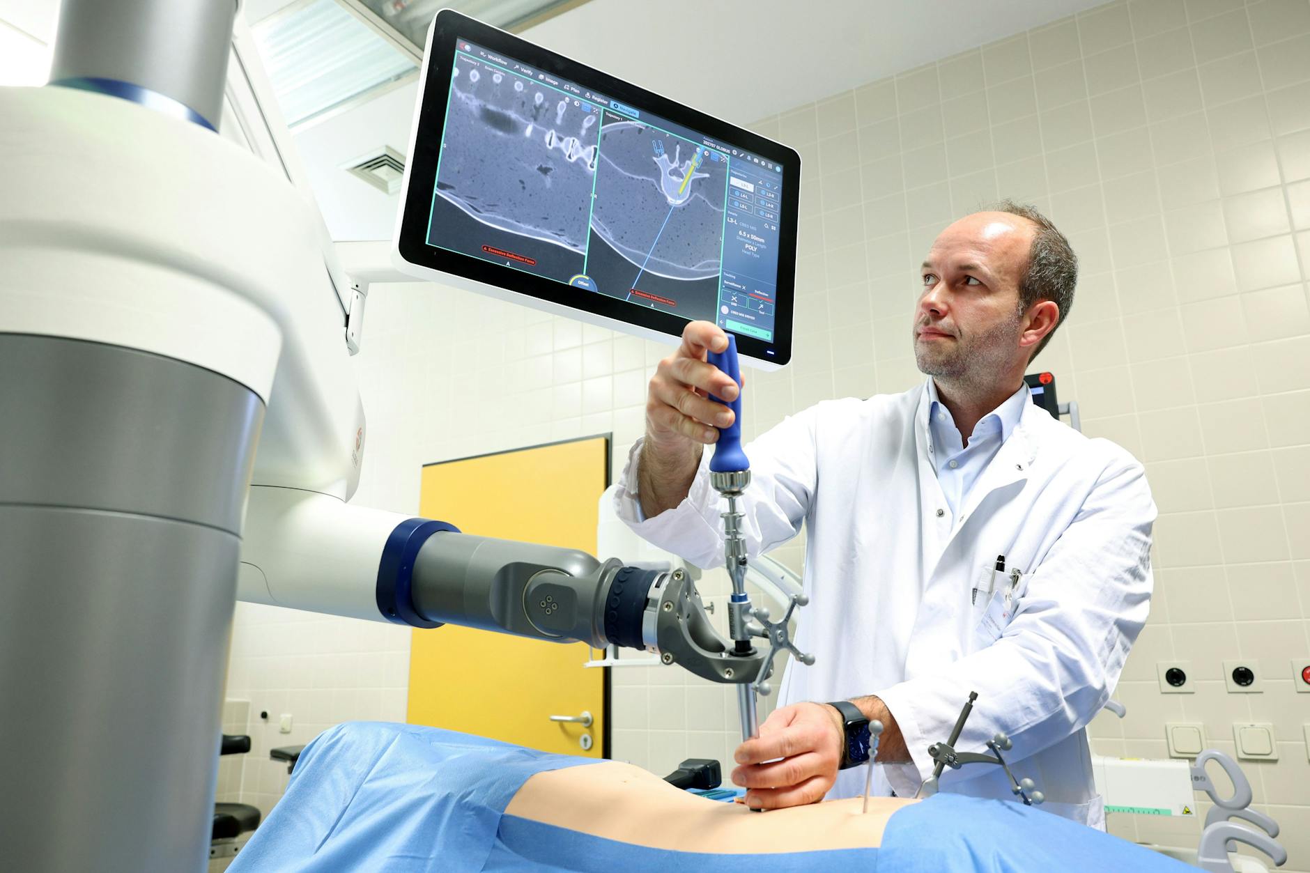 Tim Rumler-von Rüden demonstriert den OP-Roboter an einer Puppe in der Reinickendorfer Caritas-Klinik.