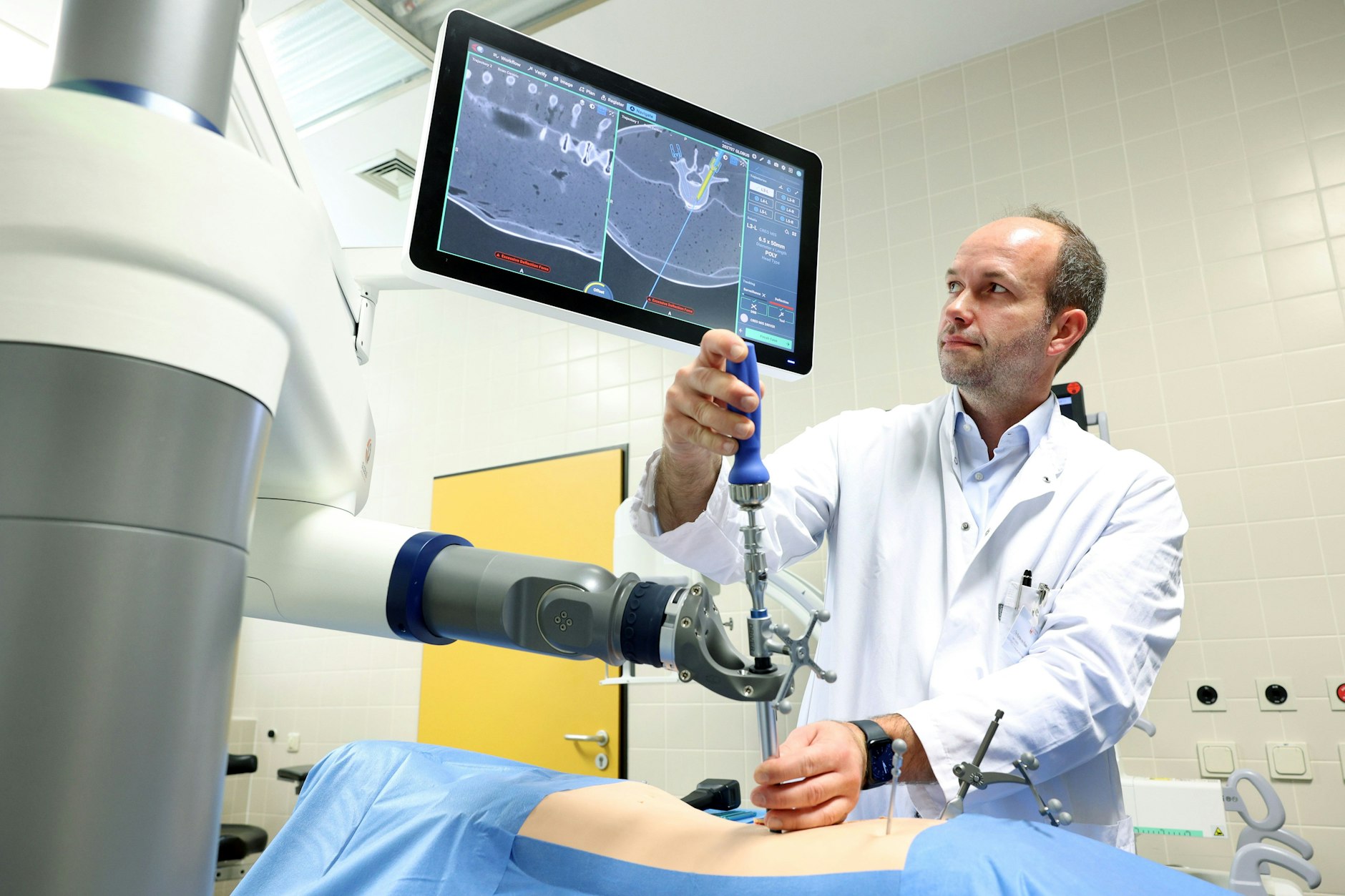 Tim Rumler-von Rüden demonstriert den OP-Roboter an einer Puppe in der Reinickendorfer Caritas-Klinik.