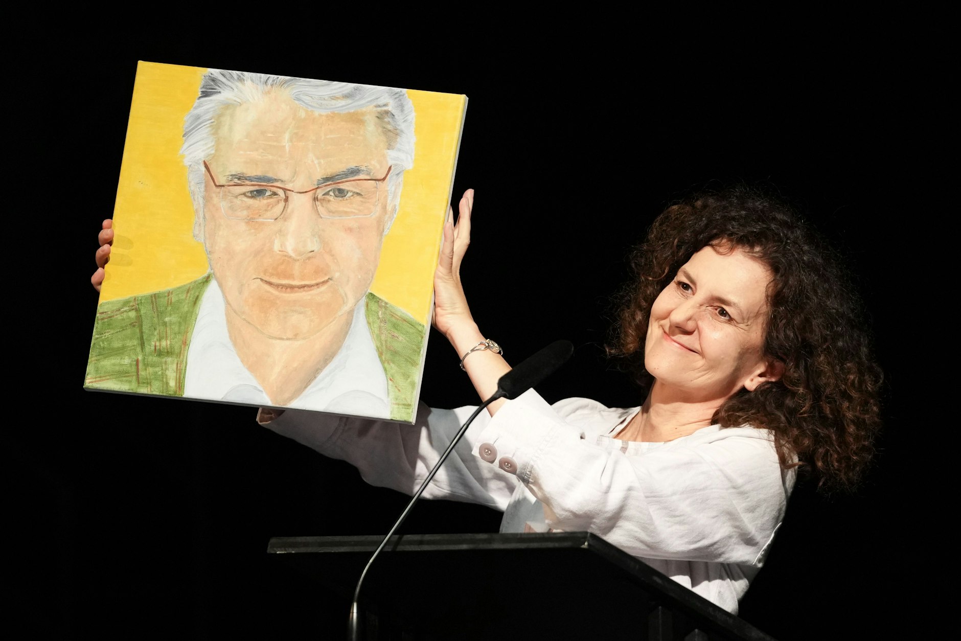 Grünes Sakko, verbindlicher Blick und eine Andeutung von Ohren. Die Dramatikerin Dea Loher zeigt während ihrer Rede zur Verabschiedung von Ulrich Khuon als Intendant des Deutschen Theaters ein von ihr gemaltes Porträt.