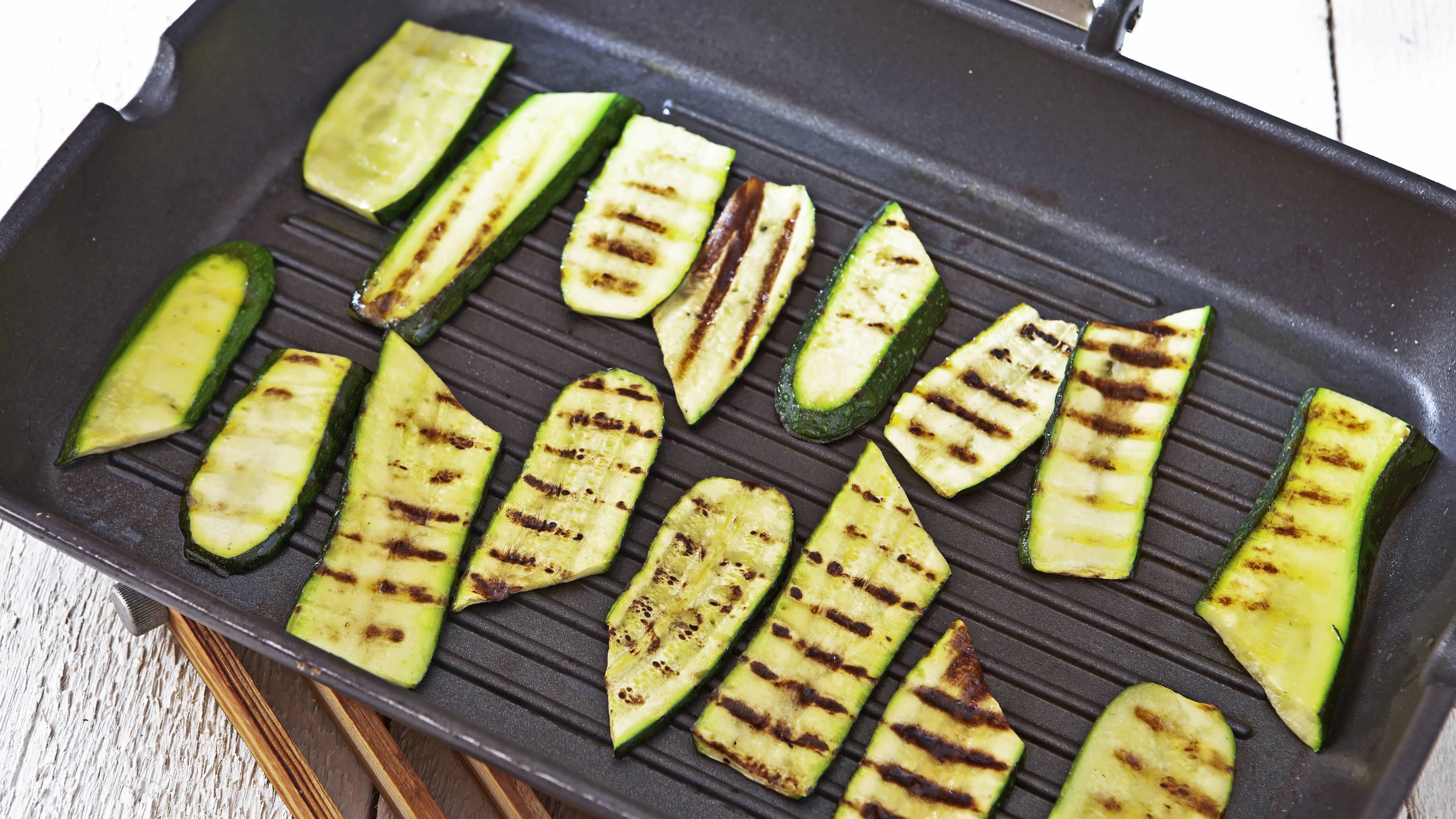 Die marinierten Zucchini-Scheiben werden gegrillt und dann mit Feta bestreut. Lecker!