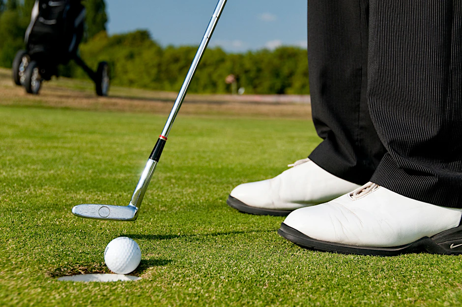 Ein Golfer versenkt den Ball in einem Loch (Symbolbild).&nbsp;