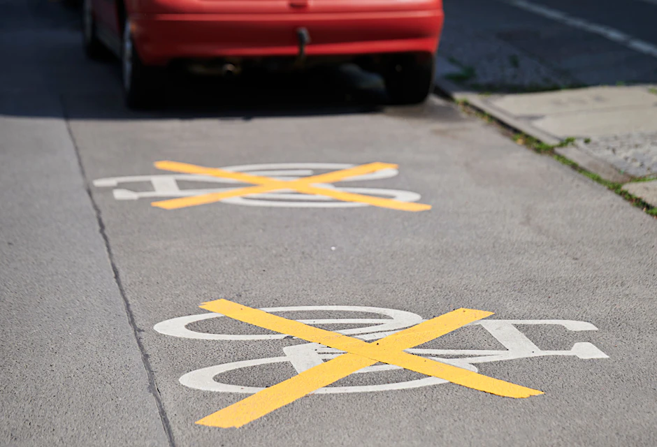 Auf der Ollenhauerstraße sind die Zeichen für den Radweg mit gelben Kreuzen zugeklebt, Autos parken darauf. Der Radweg existiert nicht mehr. Die neue Verkehrsverwaltung lässt bestimmte Radfahrprojekte ruhen. Die DUH klagt dagegen.&nbsp;