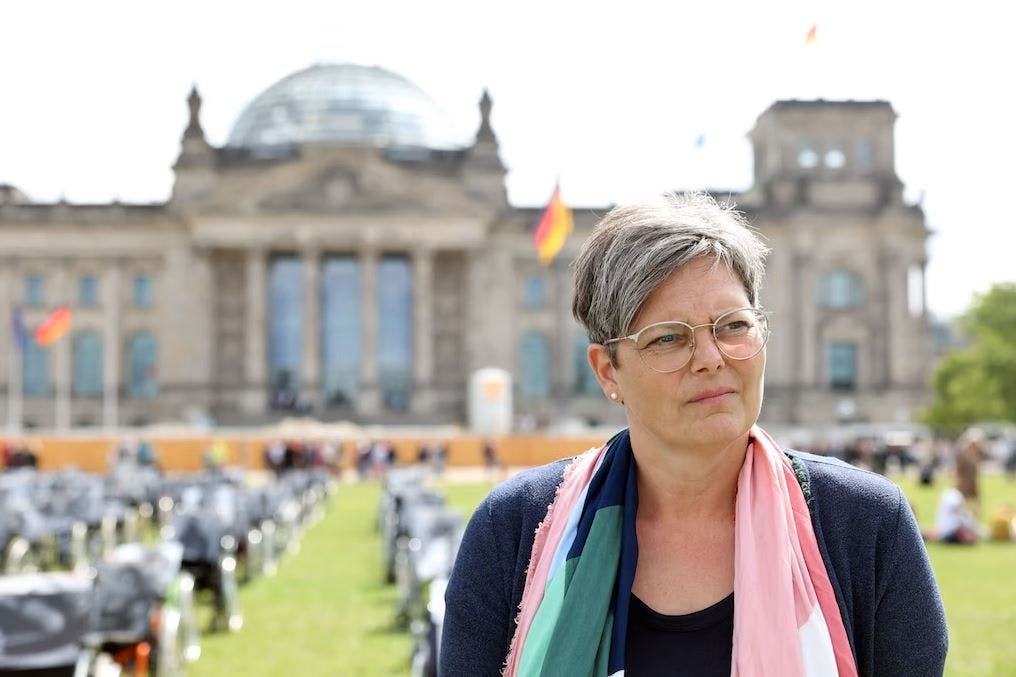 Ilka Heuer demonstriert vor dem Reichstagsgebäude. Sie ist nach Corona schwer an ME/CFS erkrankt.