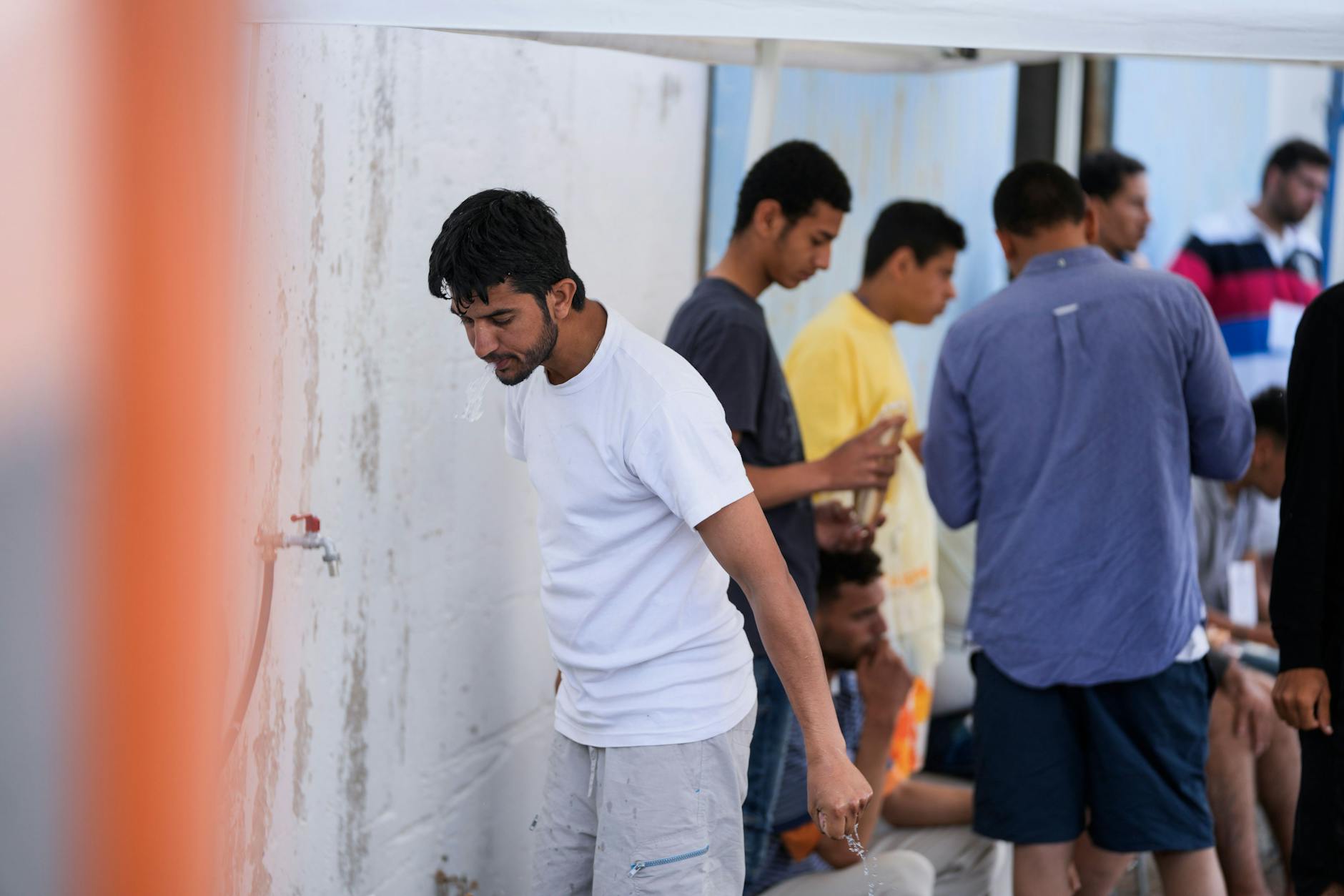 Griechenland, Kalamata: Überlebende eines Schiffsunglücks stehen vor einem Lagerhaus im Hafen der Stadt.