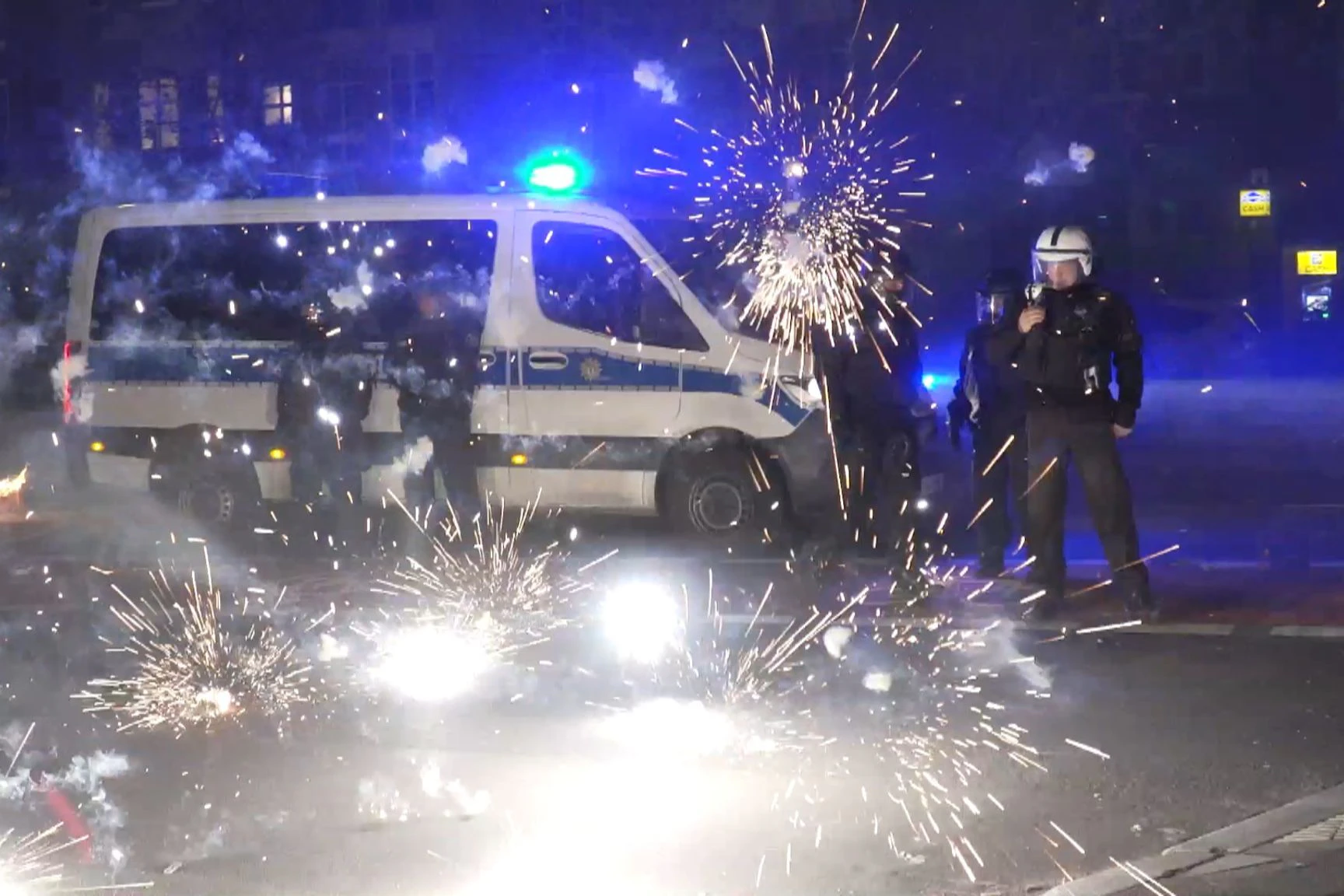 Polizeibeamte stehen in der Silvesternacht in Berlin hinter explodierendem Feuerwerk (Symbolbild). „Auch in Deutschland sind an bestimmten Orten solche Krawallexzesse denkbar“», sagt Polizei-Gewerkschafter Jochen Kopelke.  pa