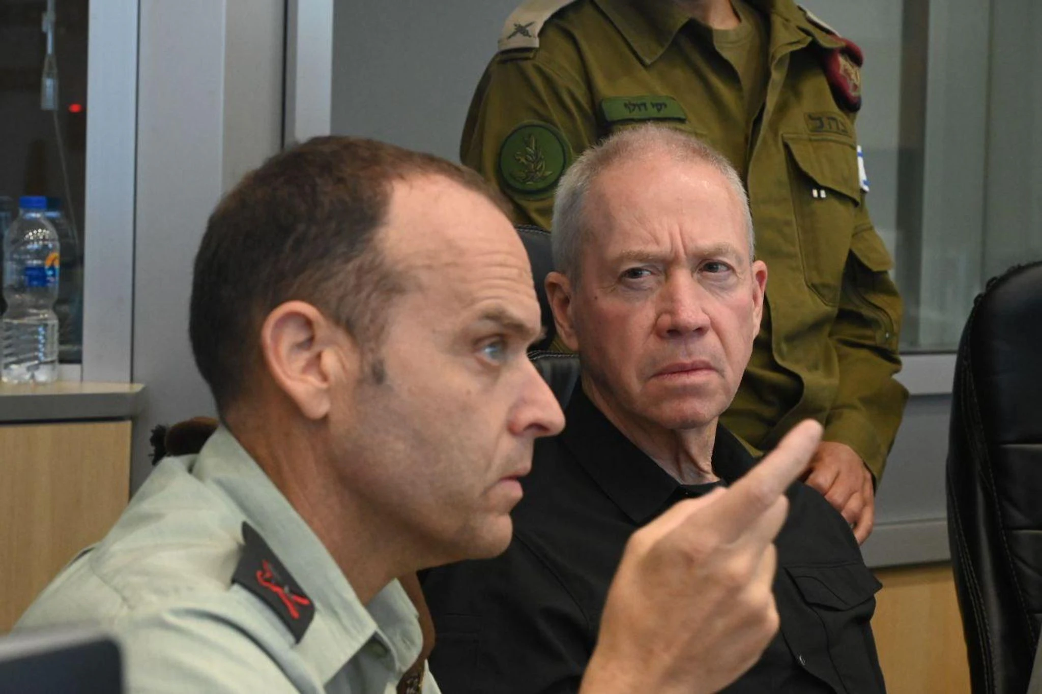 HANDOUT - Der israelische Verteidigungsminister Yoav Gallant (r) sitzt in einem Einsatzraum der Israelischen Verteidigungskräfte (IDF), während er die nächtliche Operation in der Stadt Dschenin verfolgt.   - Nutzung nur nach vertraglicher Vereinbarung
