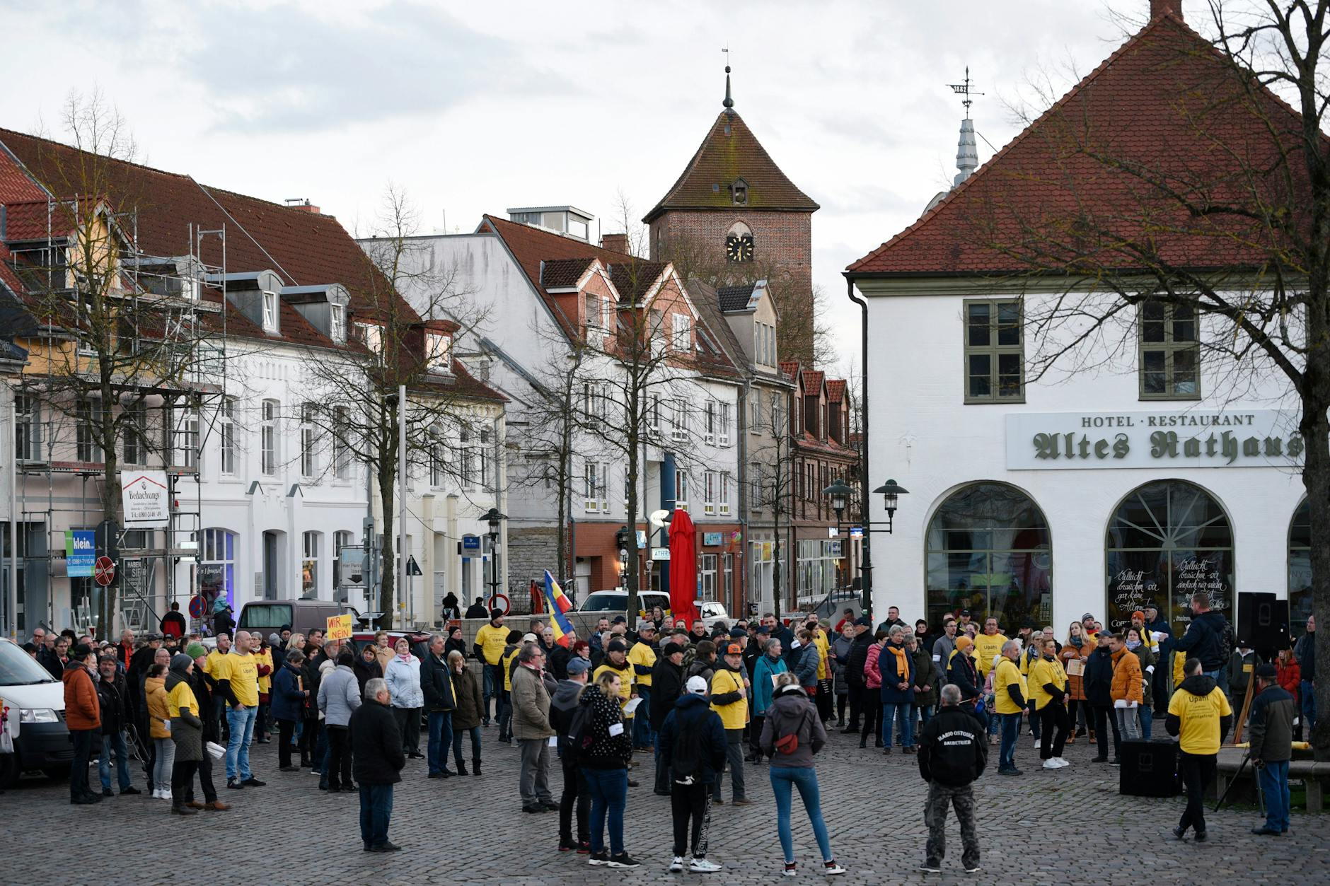 Grevesmühlen: Menschen protestieren mit Schildern und Fahnen auf einer Demonstration gegen die Flüchtlingsunterkunft im Ort Upahl auf dem Marktplatz.